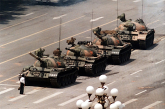 "Tank Man" temporarily stops the advance of a column of tanks on June 5, 1989, in Beijing. This photograph (one of four similar versions) was taken by Jeff Widener of the Associated Press . (Source: Wikipedia)