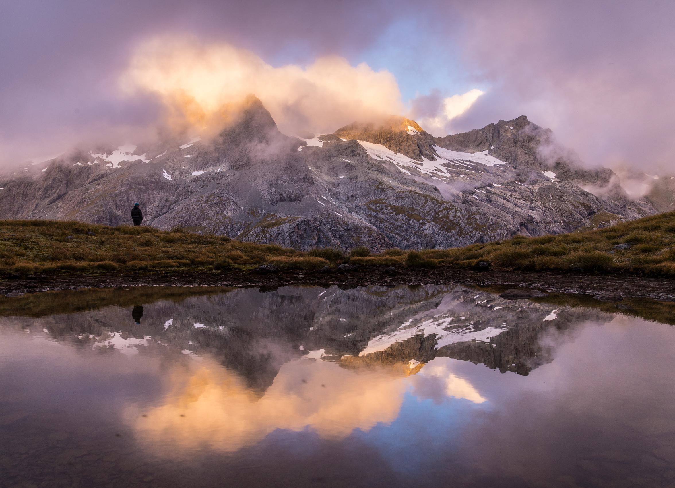 Lara next to a tarn on the Serpentine Range. It had been raining all day and we were tent bound since noon when it cleared up in the evening. Just in time to reflect the sunset clouds in the tarn.