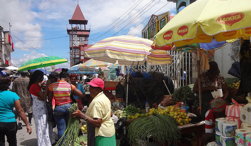 Stalls outside the old Dutch market, whose clock tower rises in the back