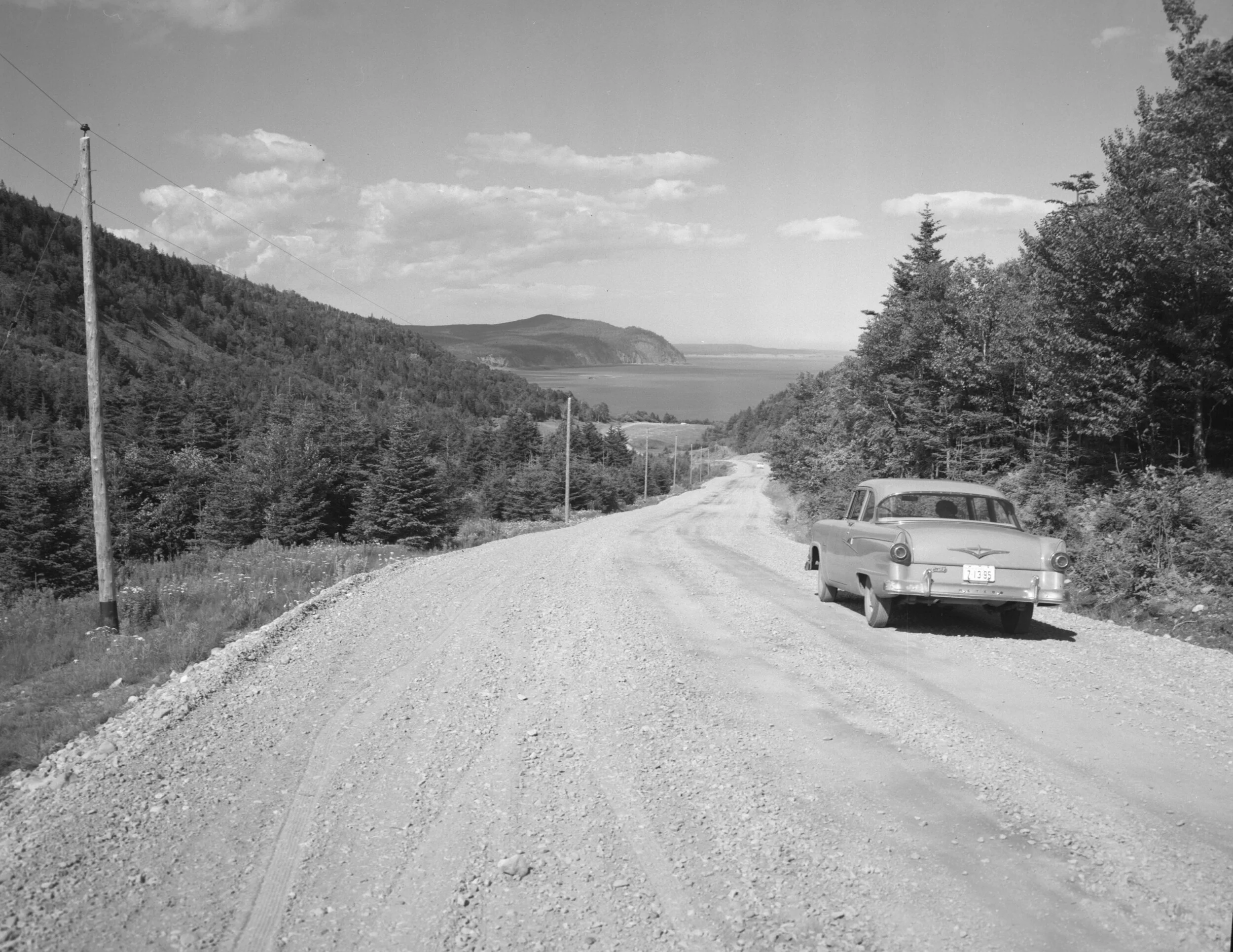 Car driving down a winding road at Fundy National Park, c.1950. From New Brunswick Provincial Archives Al-241.
