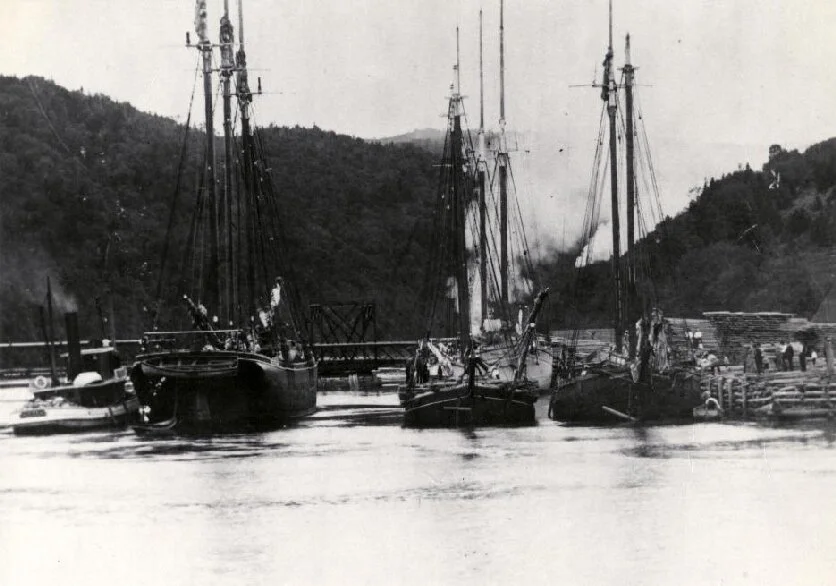 This view of the harbour in Alma shows the tugboat Stadium lining up three vessels at the dock. The vessels would be tied together at the dock before the tide went out. The vessels had to be tied together because the dock is so small. When the tide …