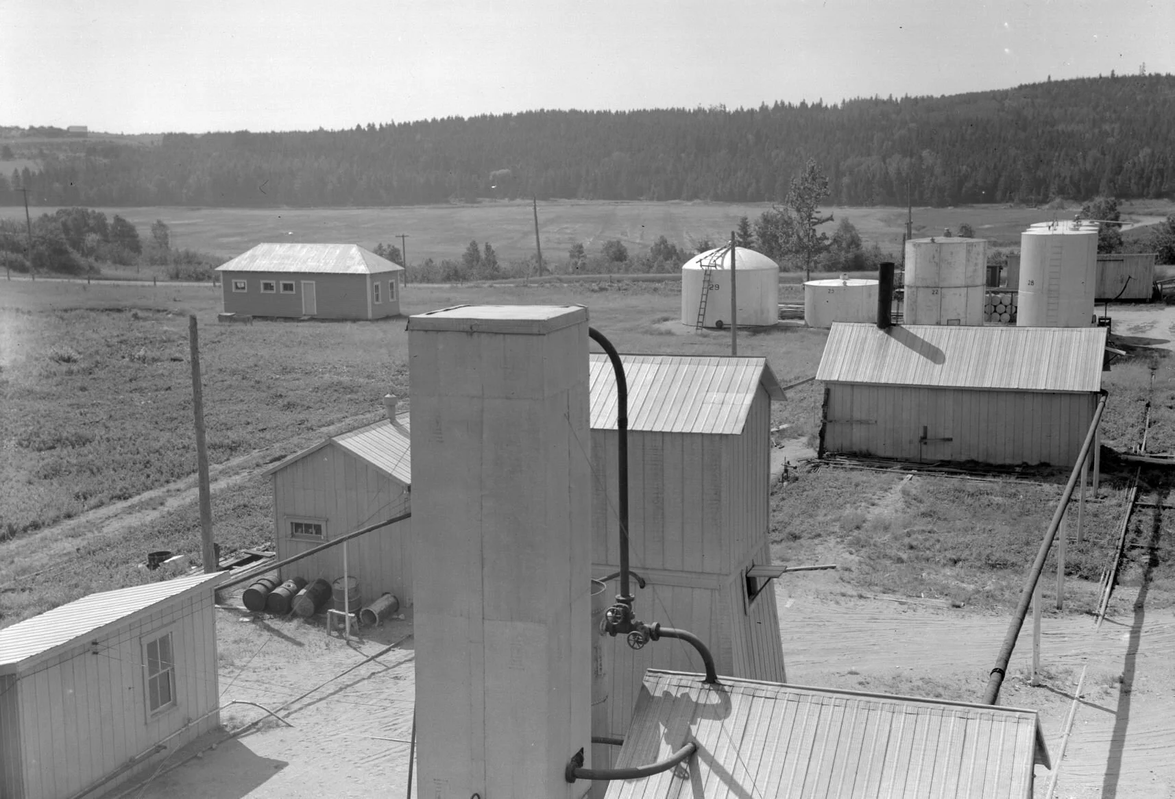 Field with buildings and various gasoline storage tanks, 1938.. From the Provincial Archives P93-AL-10.