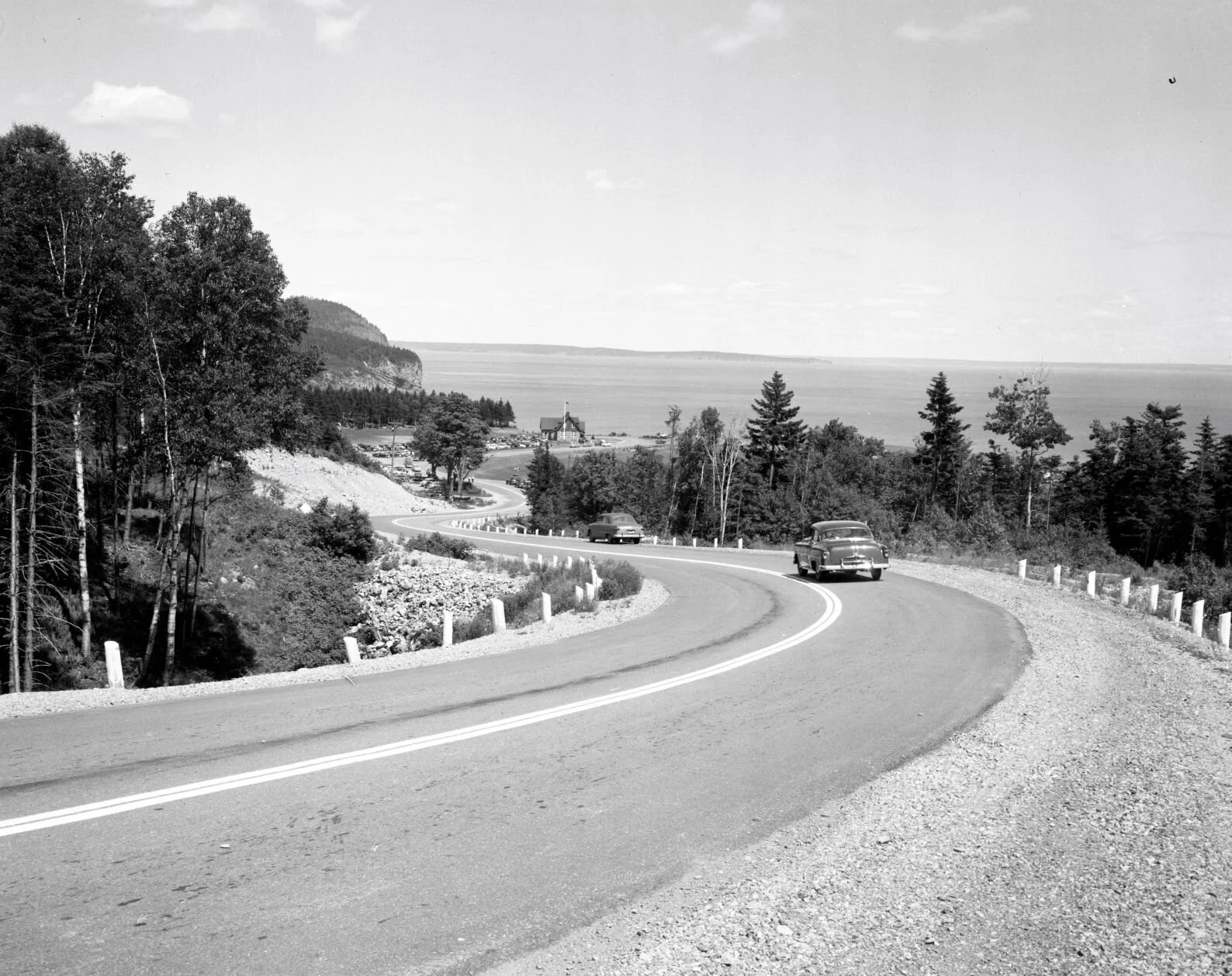 Automobiles travelling on highway leading to Fundy National Park, c.1950.. From Archives New Brunswick P93-AL-77.
