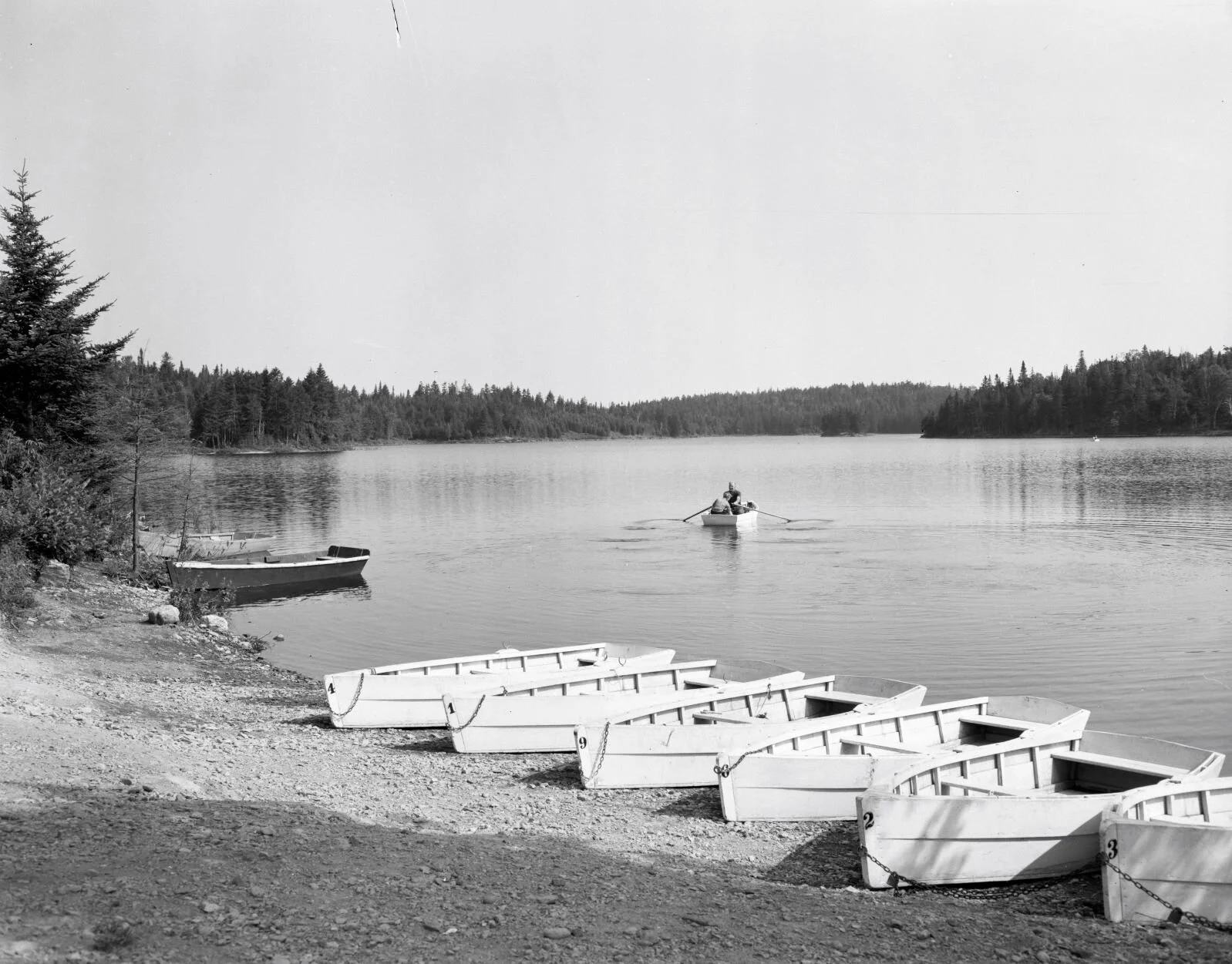 Rowboats on lake shore, Fundy National Park, c.1950... From Archives New Brunswick P93-AL-96.