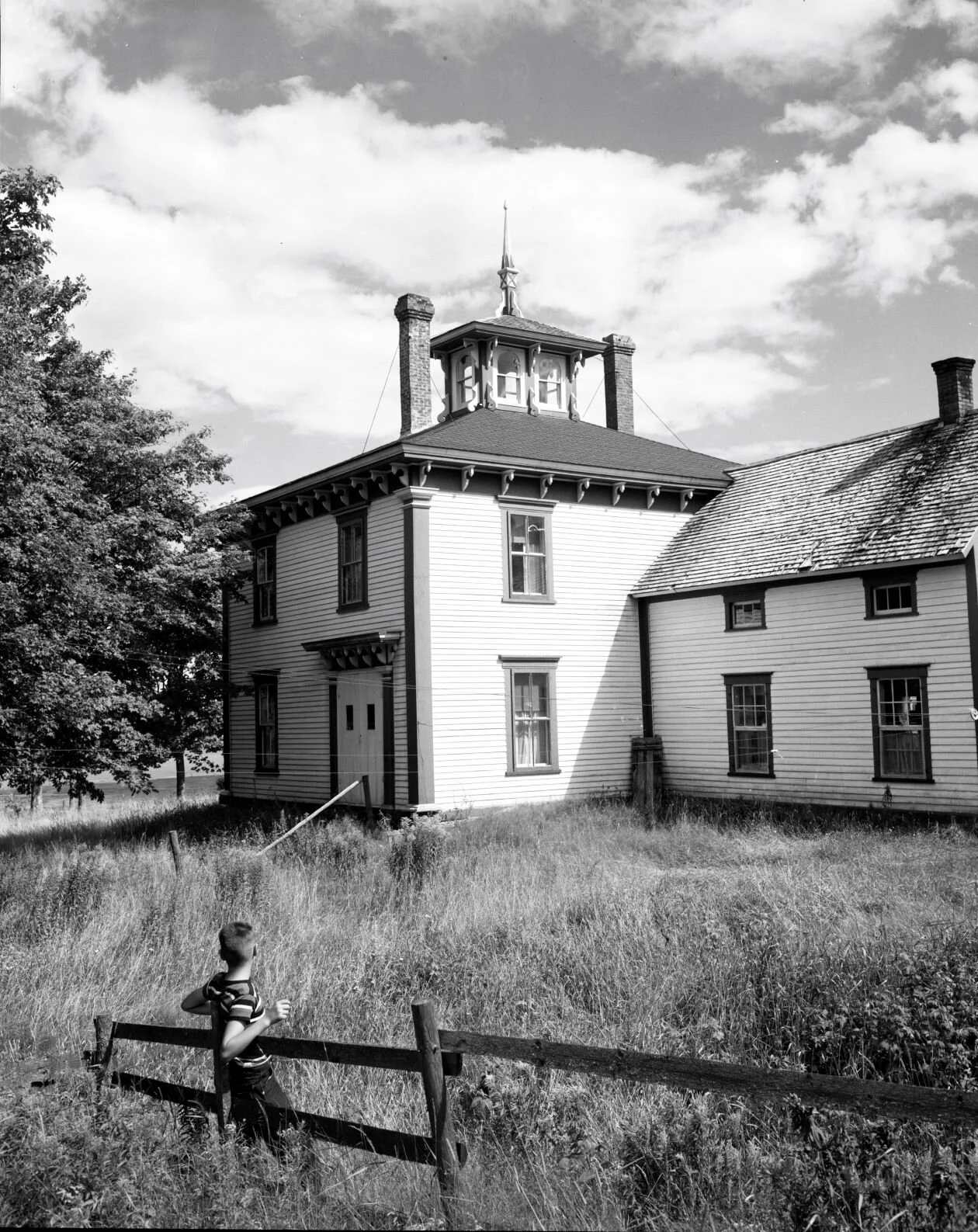 Two storey wooden house with a large Gothic arch window in front on second floor,  c.1950. From Archives New Brunswick P93-AL-84