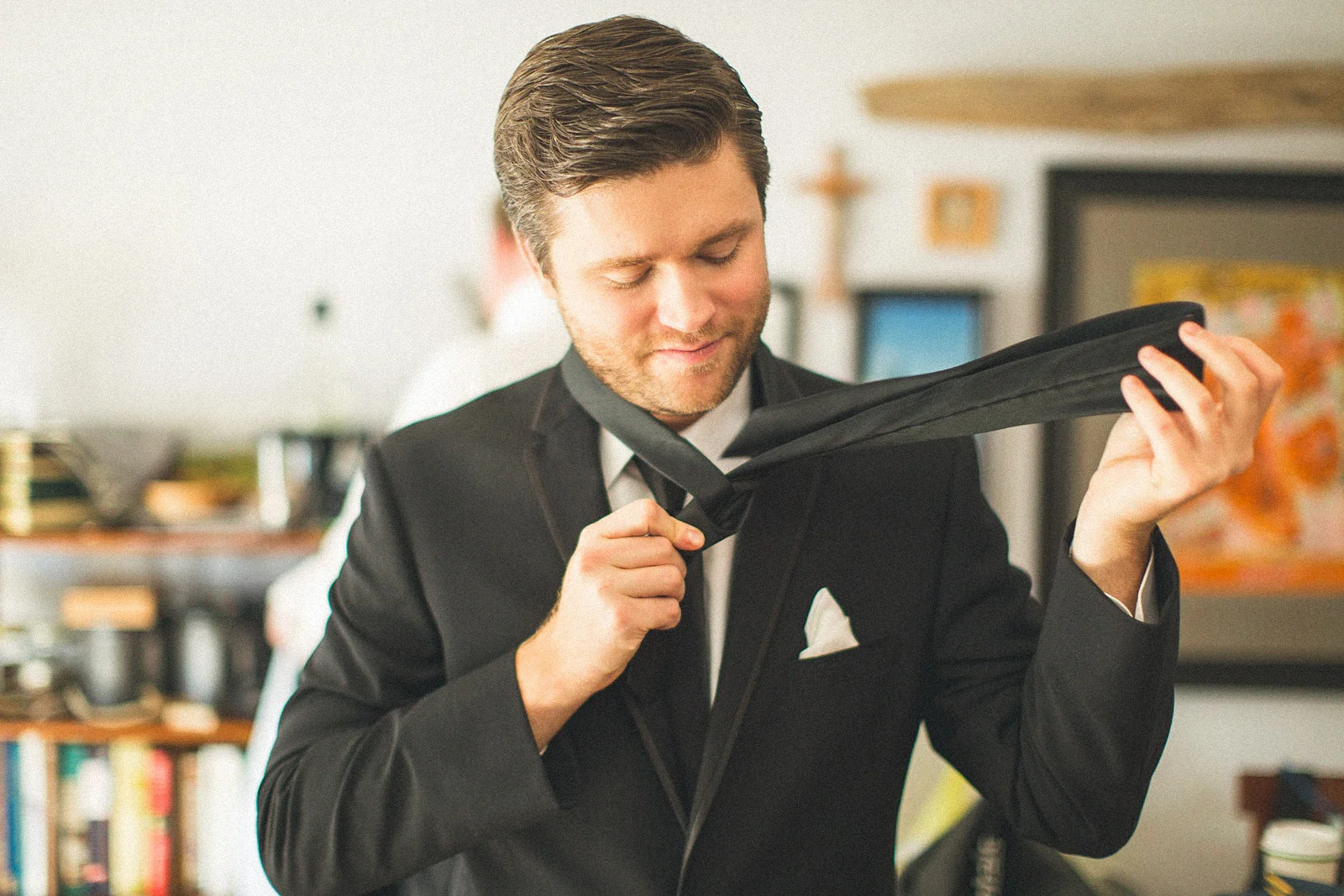 Groomsman puts on Tie