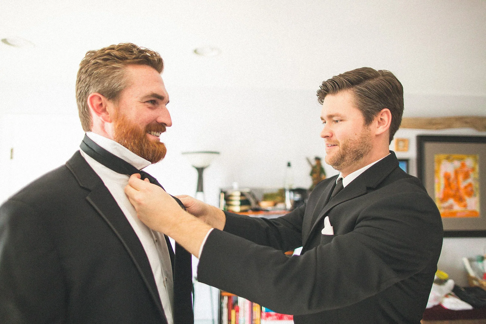 Groomsman helps with tie