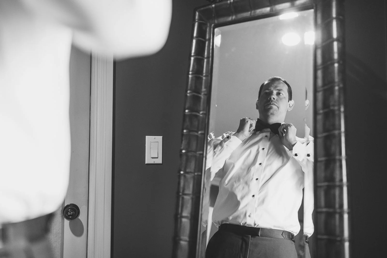 Groom adjusts bow tie
