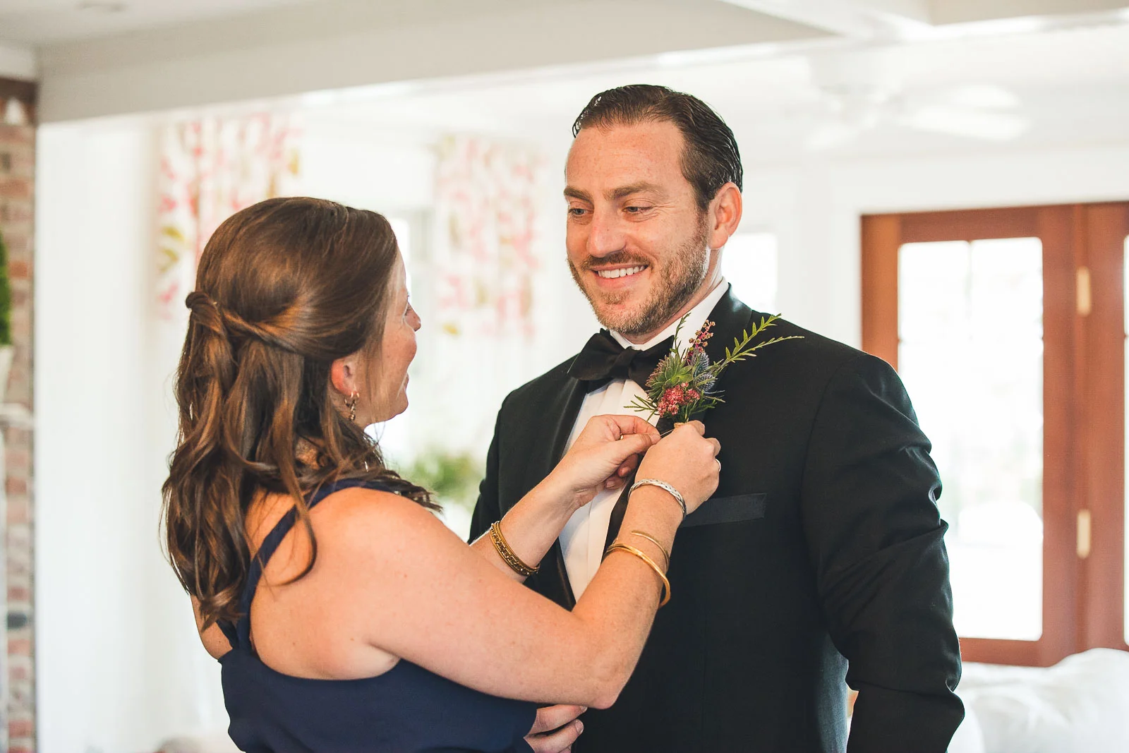 Bride sister helps groom with boutonniere