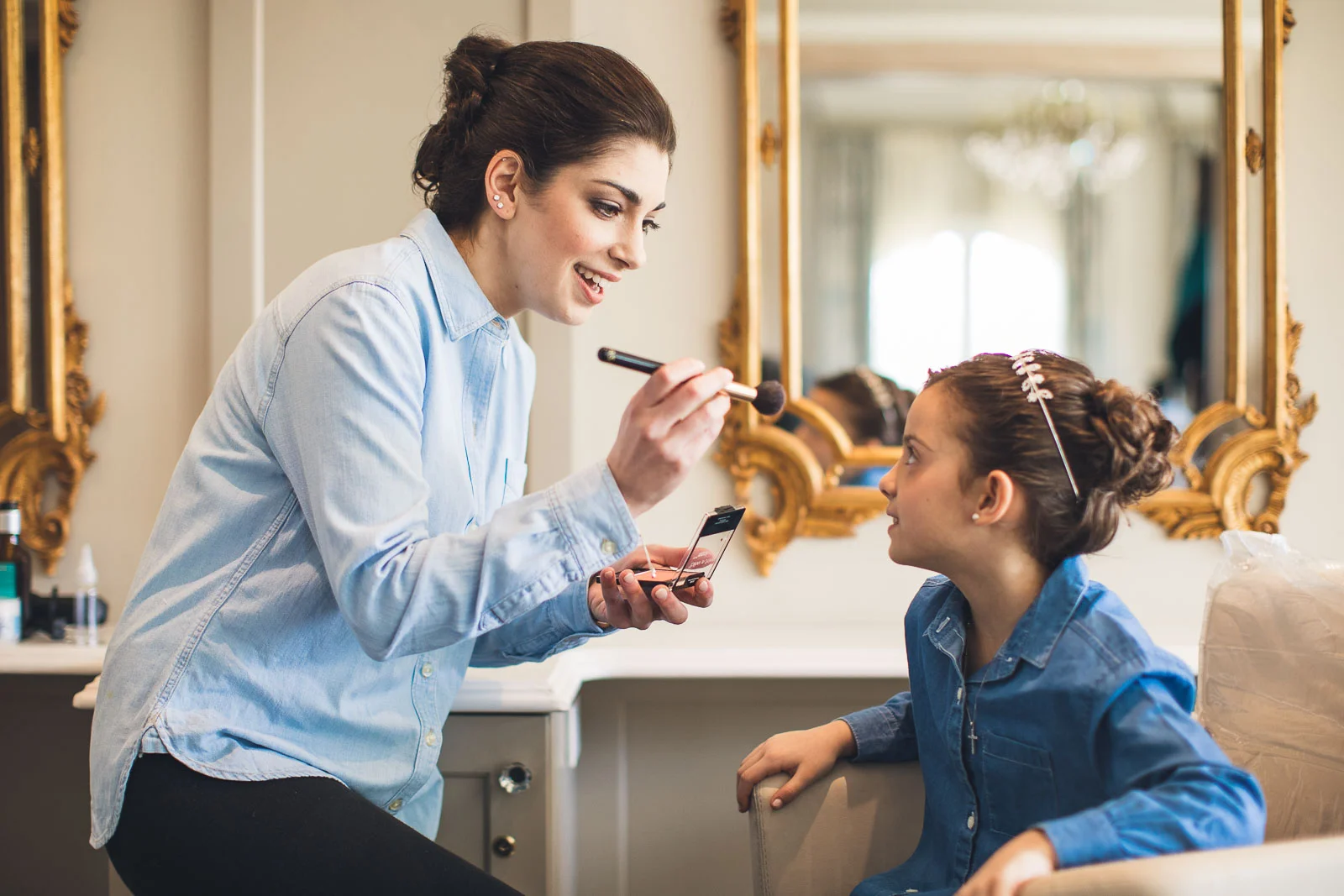 Bride helps flower girl with makeup