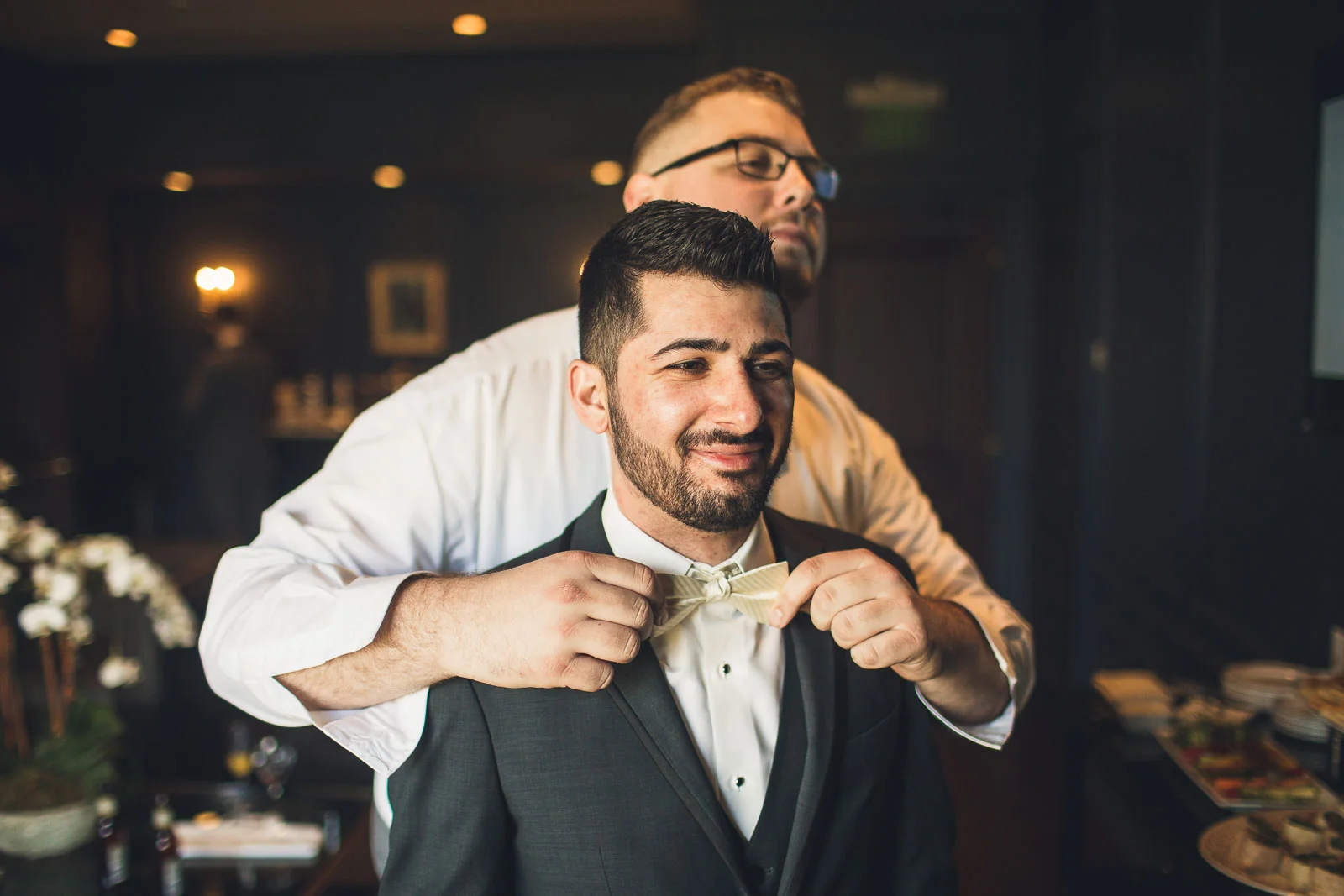 Best man helps adjust bowtie
