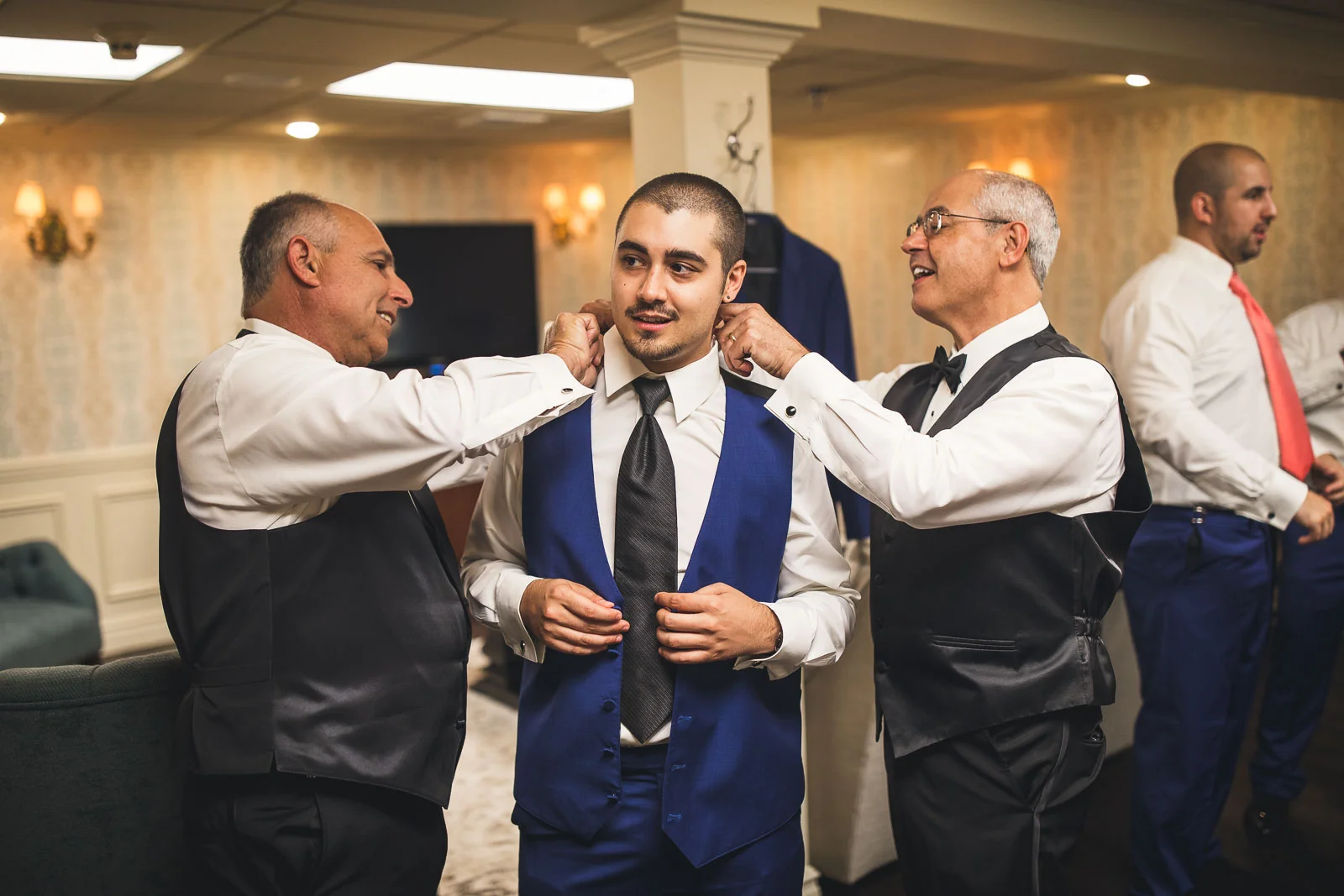 Fathers help Groom with Suit