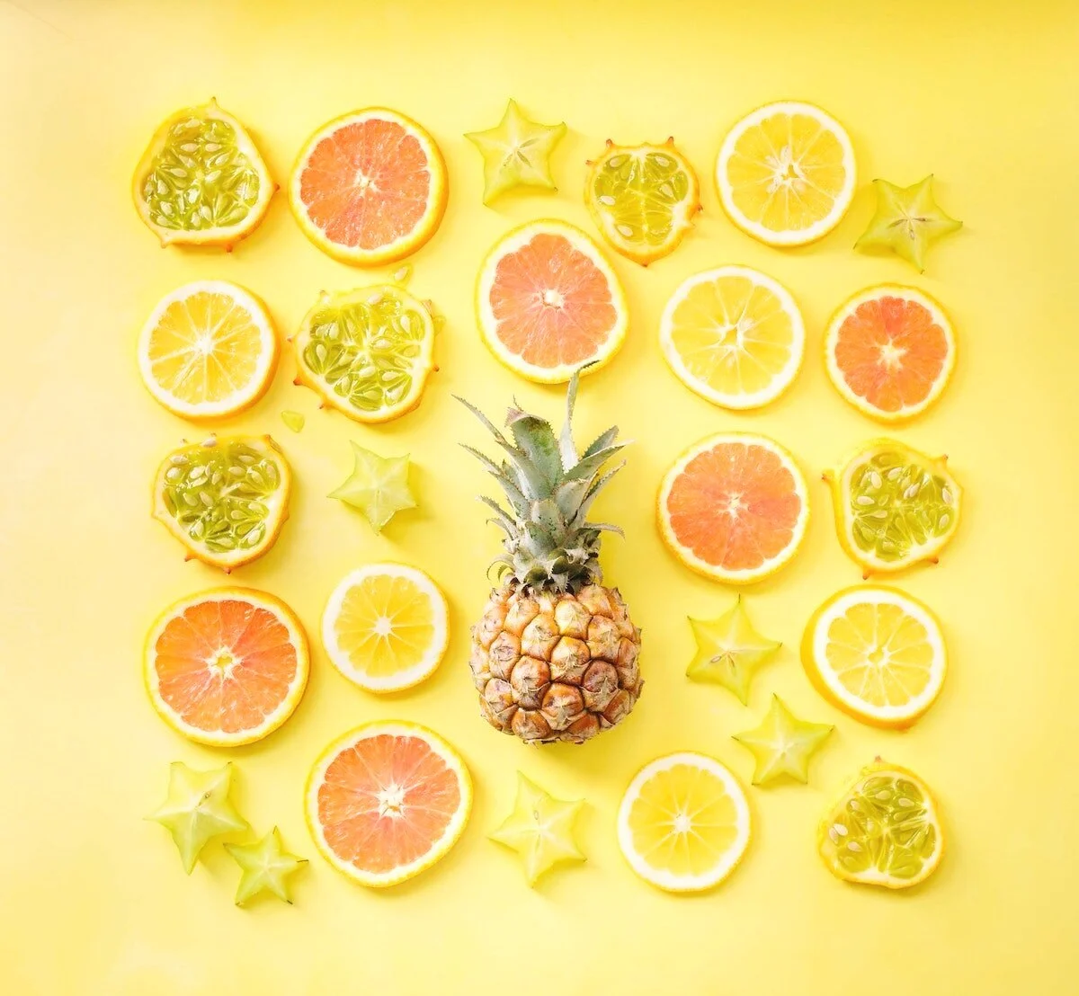 Photo pineapples, grapefruit and lemons in a square block on yellow background by Brooke Lark on Unsplash