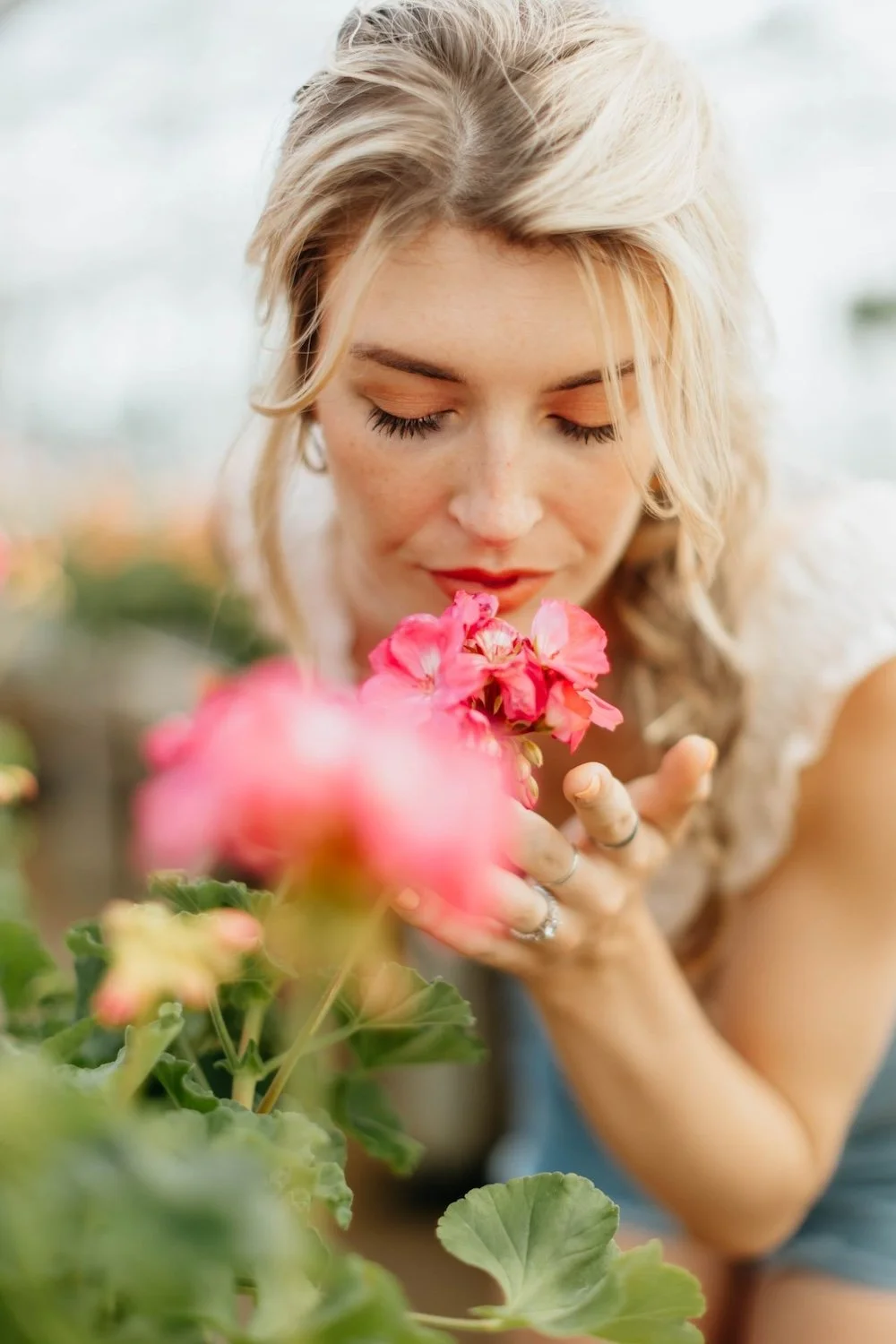 Photo blonde woman smelling rose by Leah Newhouse on Pexels