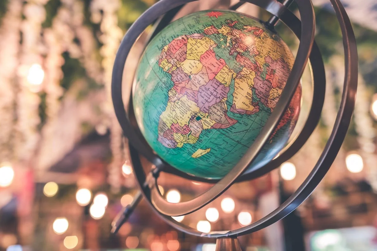Photo of a globe on a spinner with bokeh background by Artem Beliaikin from Pexels