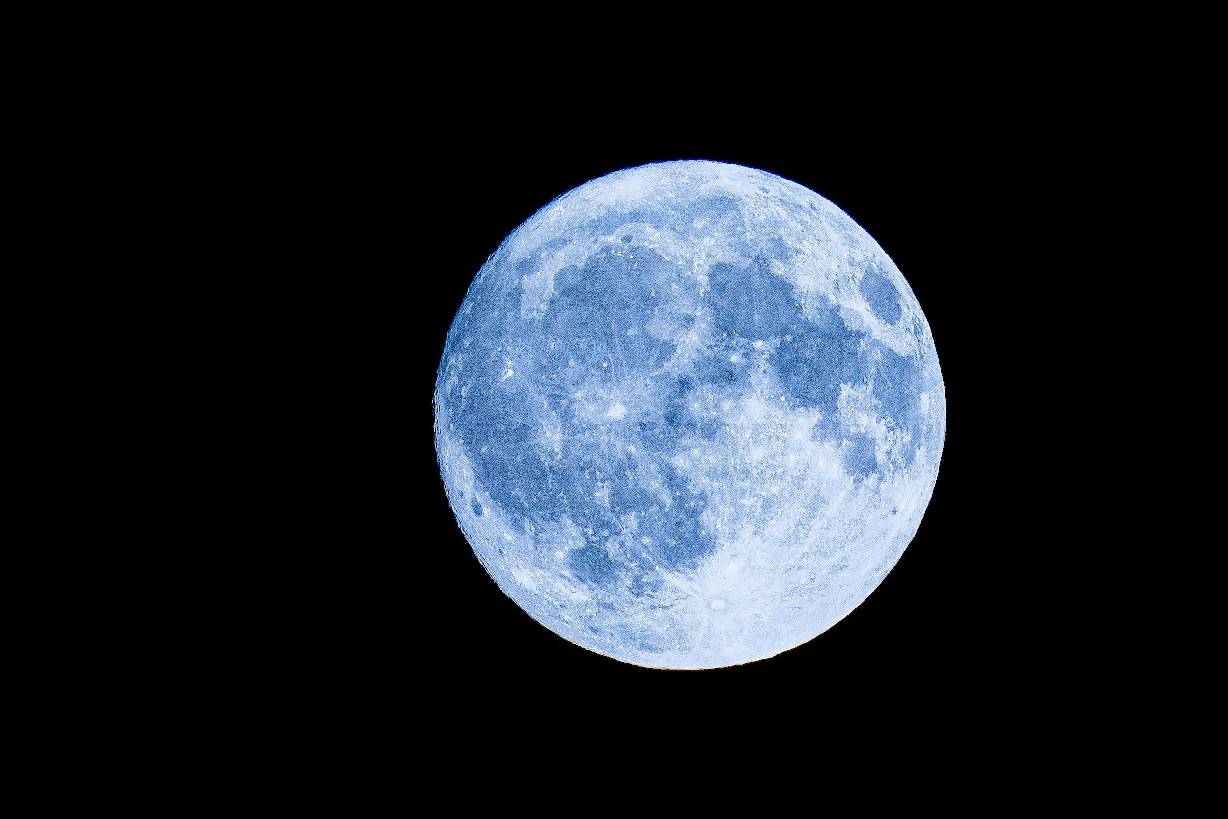 Bright blue moon with textured surface on black background by Nikola Tomašić on Pexels