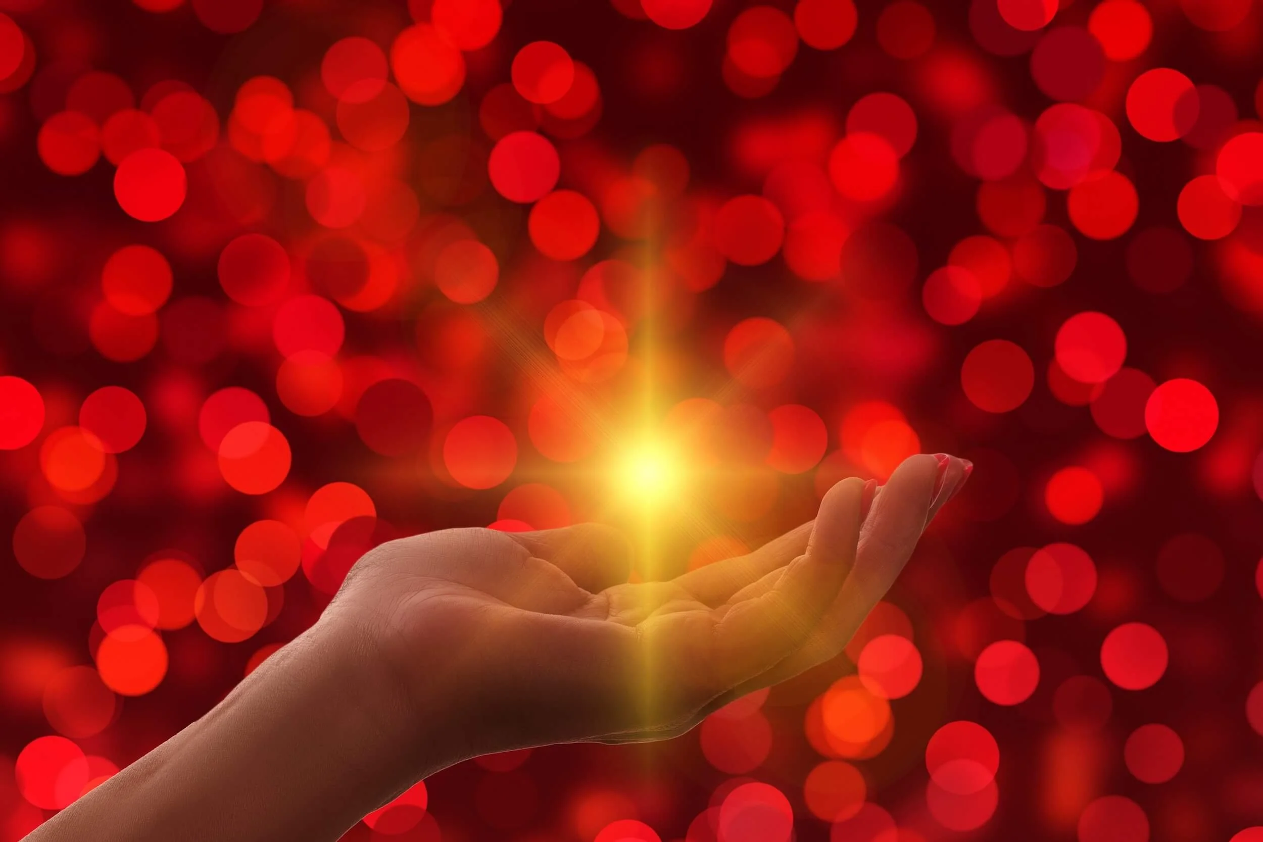 Image of red bokeh orbs with golden light in hand by Gerd Altmann from Pixabay