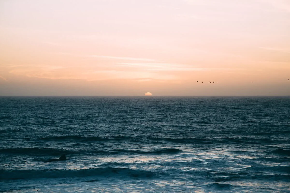 Photo of a peaceful peace moon along an ocean horizon by Colin Maynard on Unsplash
