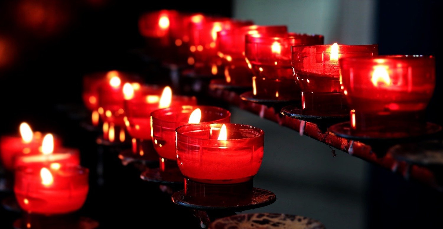 Candles in red holders in tiered rows from Pixabay