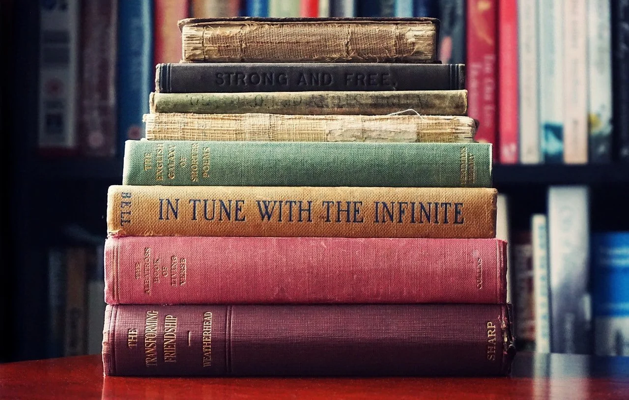 Photo of stack of books with titles, In Tune With The Infinite, and Strong And Free, by Suzy Hazelwood from Pexels