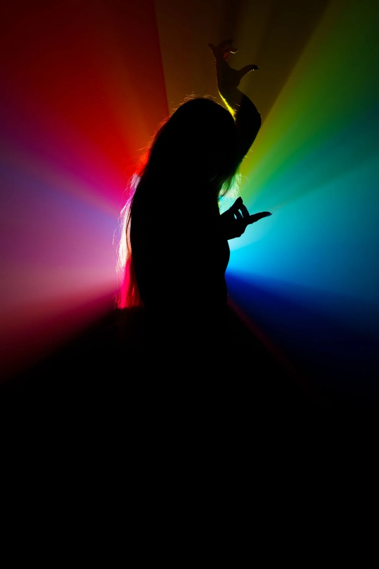 person surrounded by rainbow light