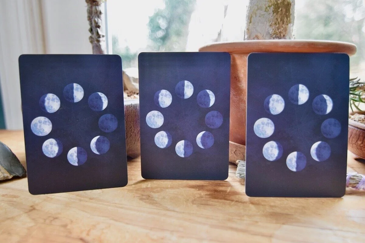 Photo by Amanda Linette Meder, featuring the three backs of the Moonology Oracle Cards which are the moon cycle from full to new in a circle