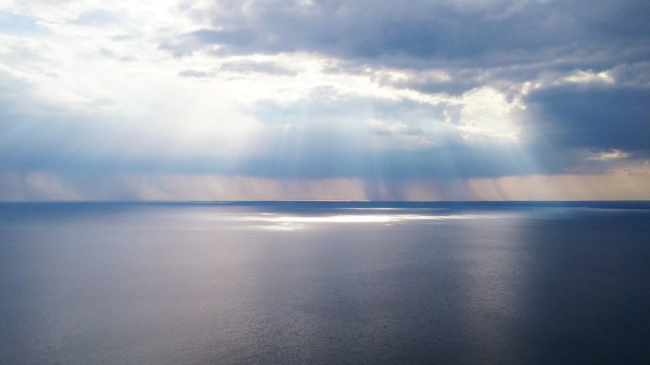 Photo of open water with light rays shining down by Pixabay from Pexels