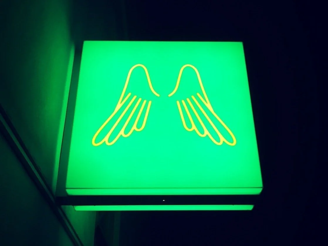 Photo of angel wings on neon sign by Paul Engel on Unsplash
