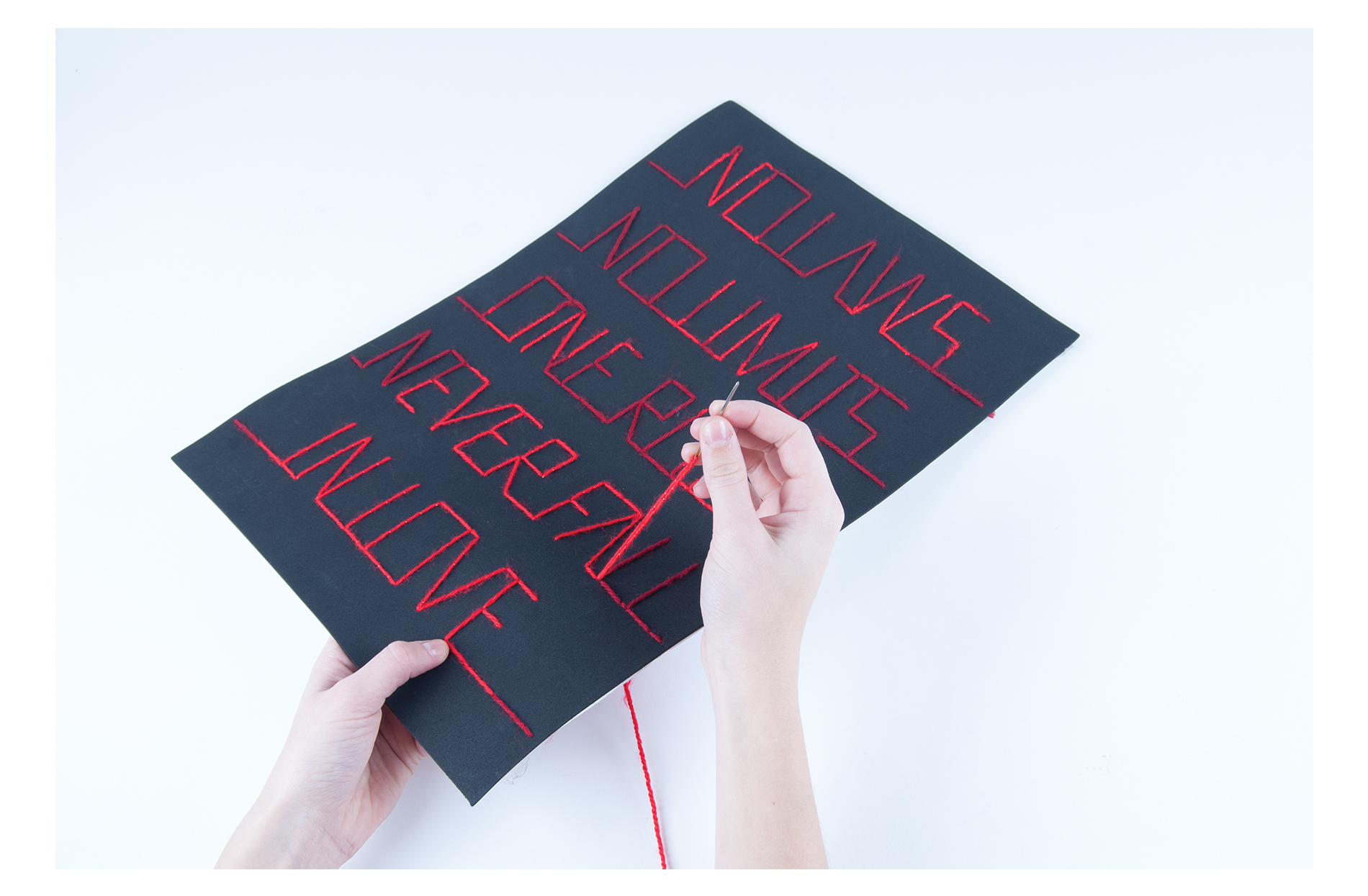 The famous tagline of the film Moulin Rouge is 'No laws, no limits, one rule: never fall in love was used as an inspiration for this handmade project. The type is all sown with the use of two different colours of wool. By using the brighter red, the