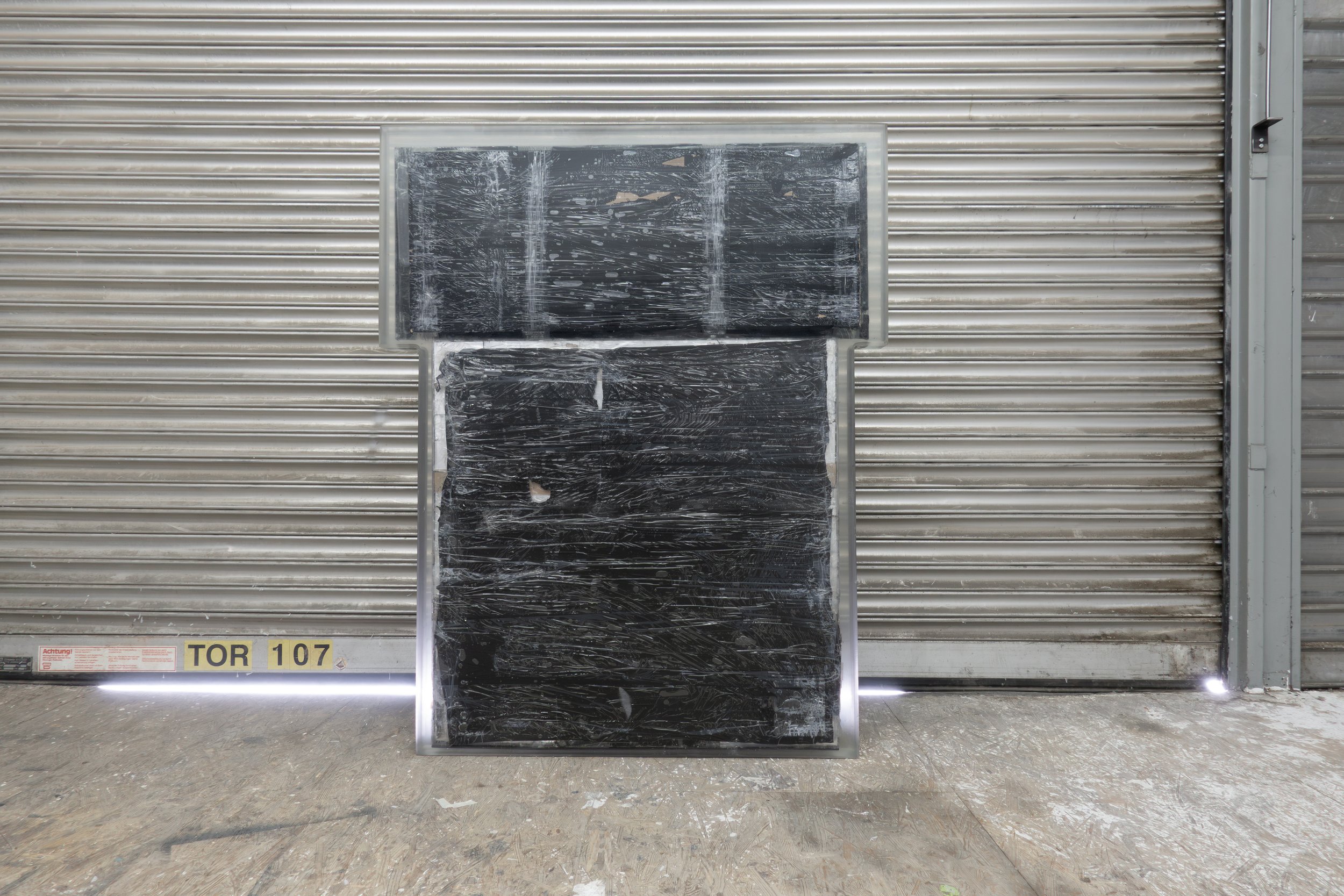  JASON GRINGLER.  TOMB (2026).  STUDIO VIEW.  FAILED ARTWORK, STEEL, PLASTIC WRAP, ALUMINUM TAPE, PACKING TAPE, PIGMENT, WOOD, OBSOLETE TECH, RUST, EPOXY, WAX AND ADHESIVES.  8.5 X 106.5 X 134 CM. 
