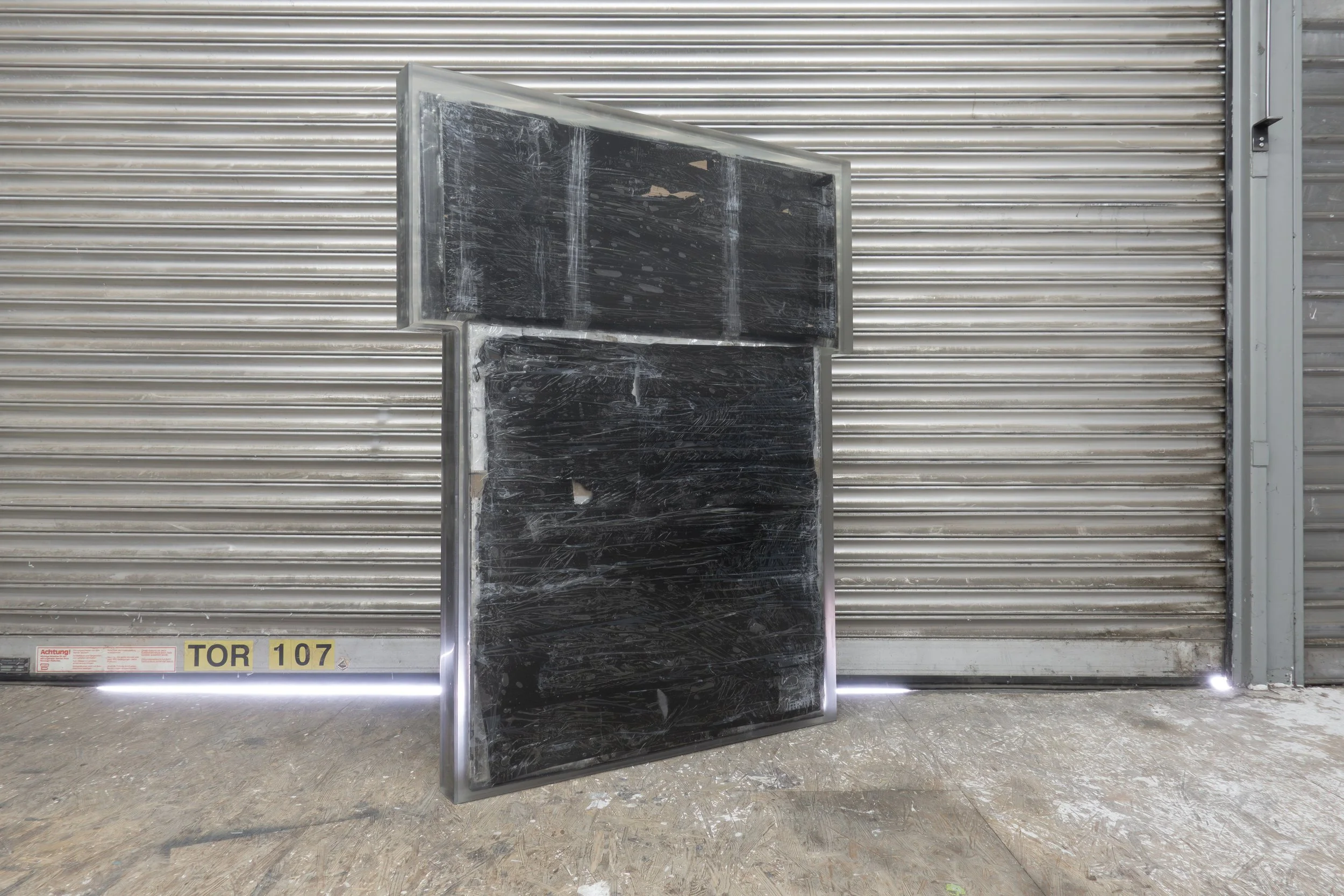  JASON GRINGLER.  TOMB (2026).  STUDIO VIEW.  FAILED ARTWORK, STEEL, PLASTIC WRAP, ALUMINUM TAPE, PACKING TAPE, PIGMENT, WOOD, OBSOLETE TECH, RUST, EPOXY, WAX AND ADHESIVES.  8.5 X 106.5 X 134 CM. 