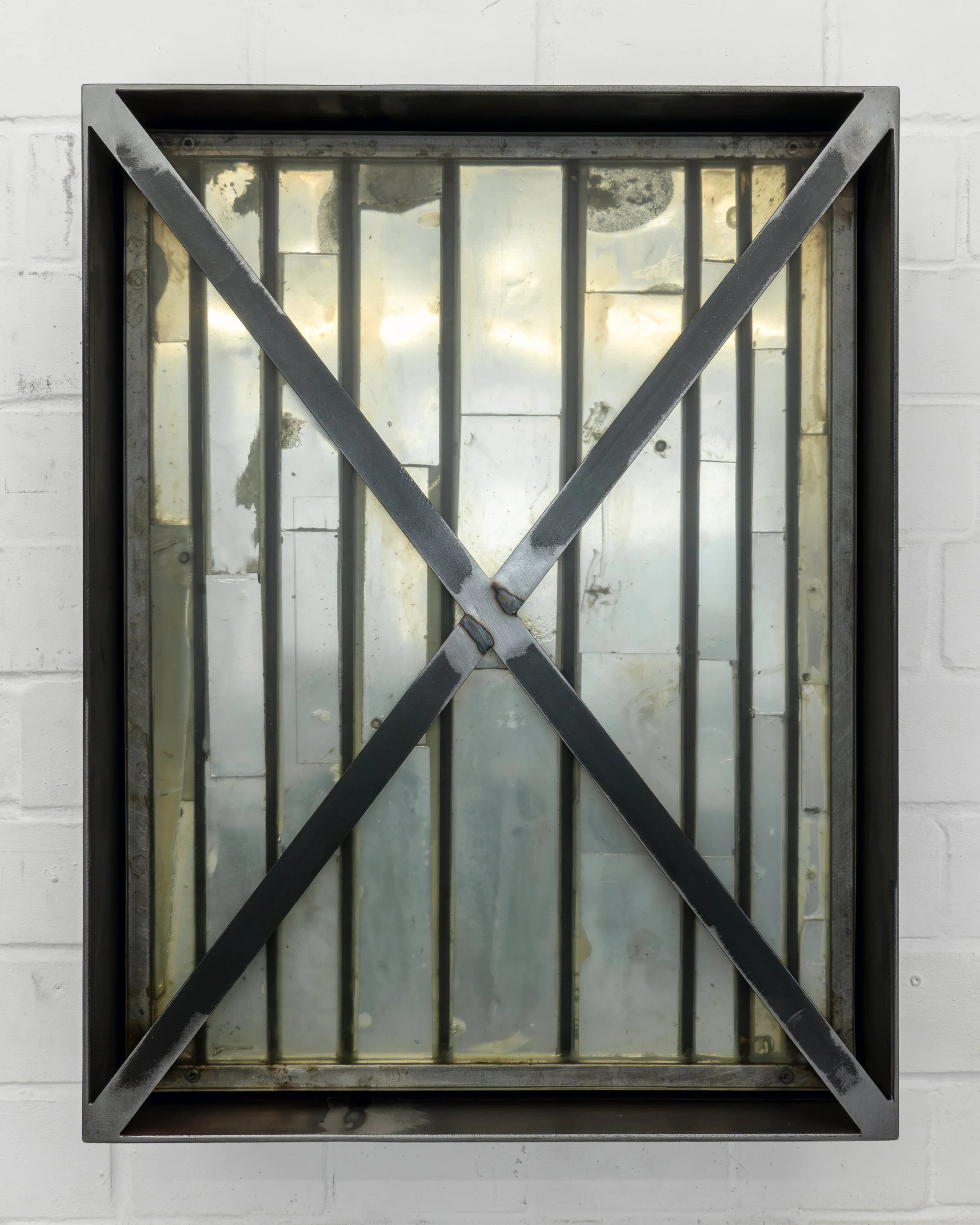  JASON GRINGLER.  (DEFACED) MONOCHROME (X) (2018-2026).  STUDIO VIEW.  STEEL, MIRRORED GLASS, PIGMENT, HARDWARE, EPOXY, RUST, WAX, ADHESIVES.  20 X 60.5 X 79 CM. 