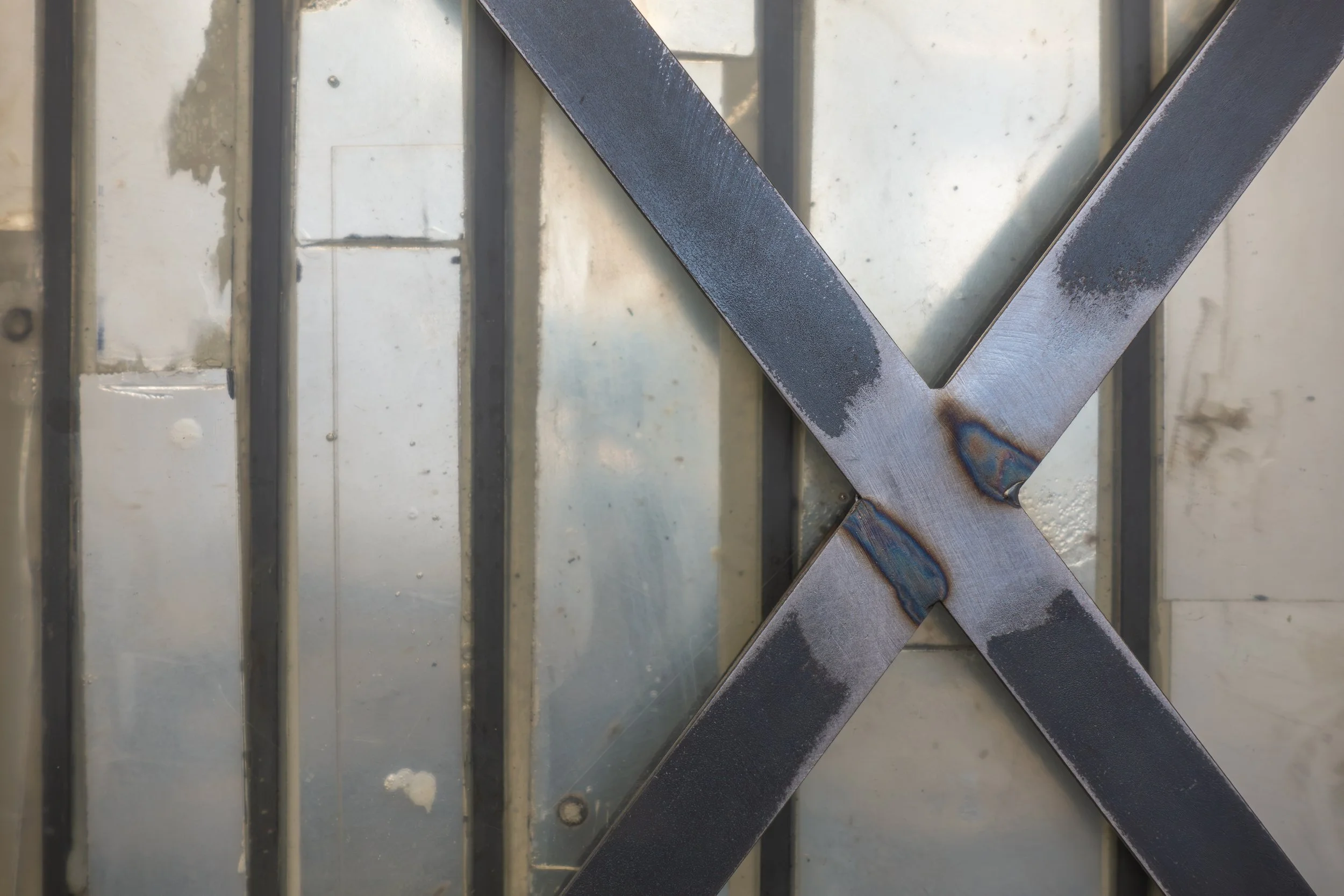  JASON GRINGLER.  (DEFACED) MONOCHROME (X) (2018-2026) (DETAIL).  STUDIO VIEW.  STEEL, MIRRORED GLASS, PIGMENT, HARDWARE, EPOXY, RUST, WAX, ADHESIVES.  20 X 60.5 X 79 CM. 