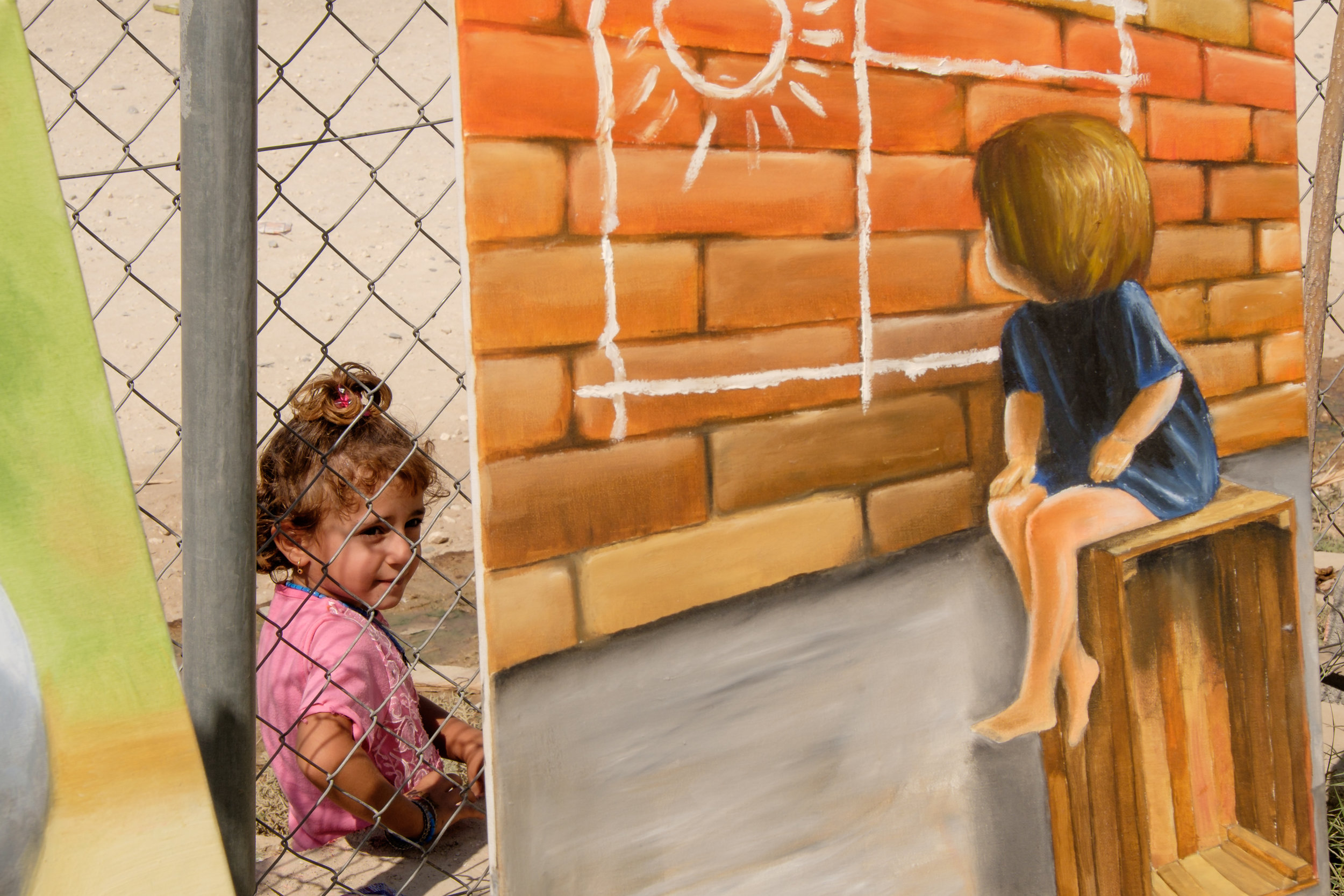 Kurdistan Region of Iraq. IDP Camp Kabarto II. A young girl watches the exhibition of Artist Saad Abduhamid Khalil from the outside. Khalil´s pictures were exhibited in the context of a chess tournament between to IDP-Camps, conducted by local NGO Harikar.