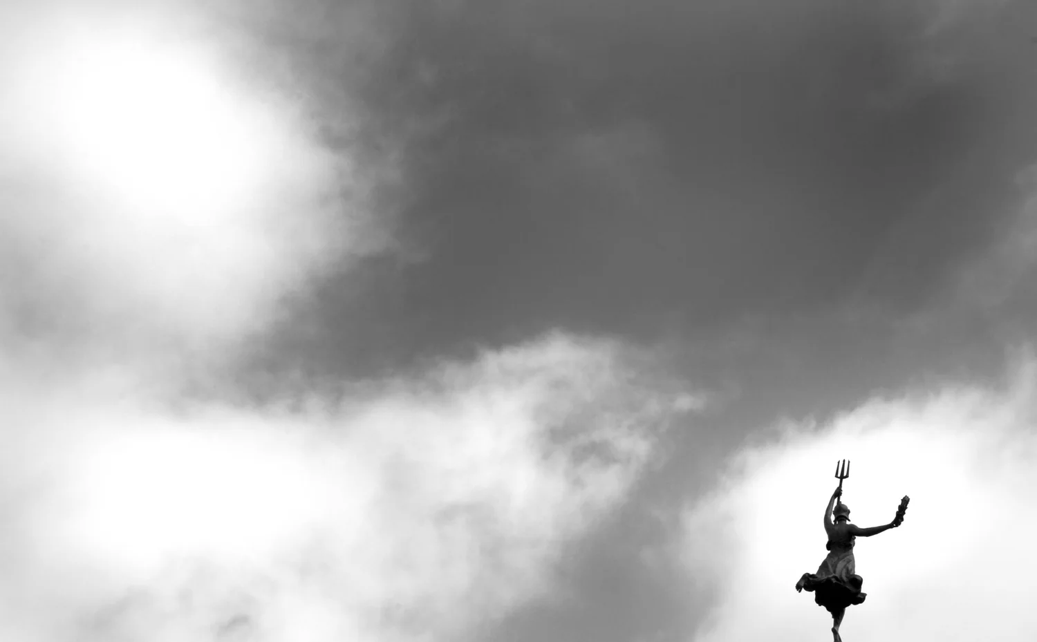 Person beneath a dramatic sky, black and white photograph.
