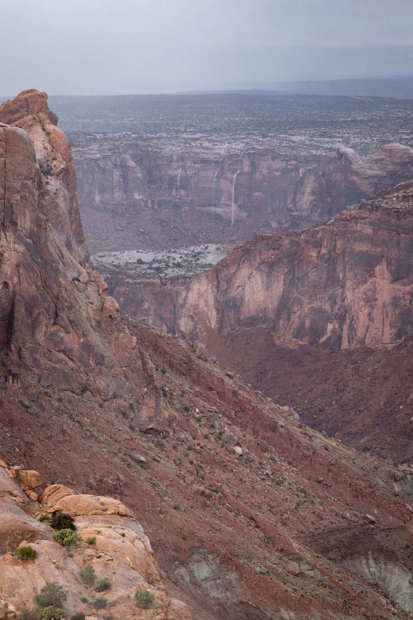 Rain pours over the canyon walls near Upheaval Dome