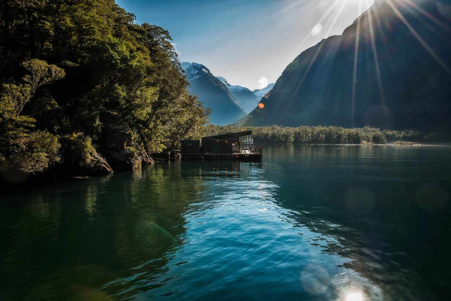 Light flare above the spectacular Milford Sound in Fiordland, New Zealand.