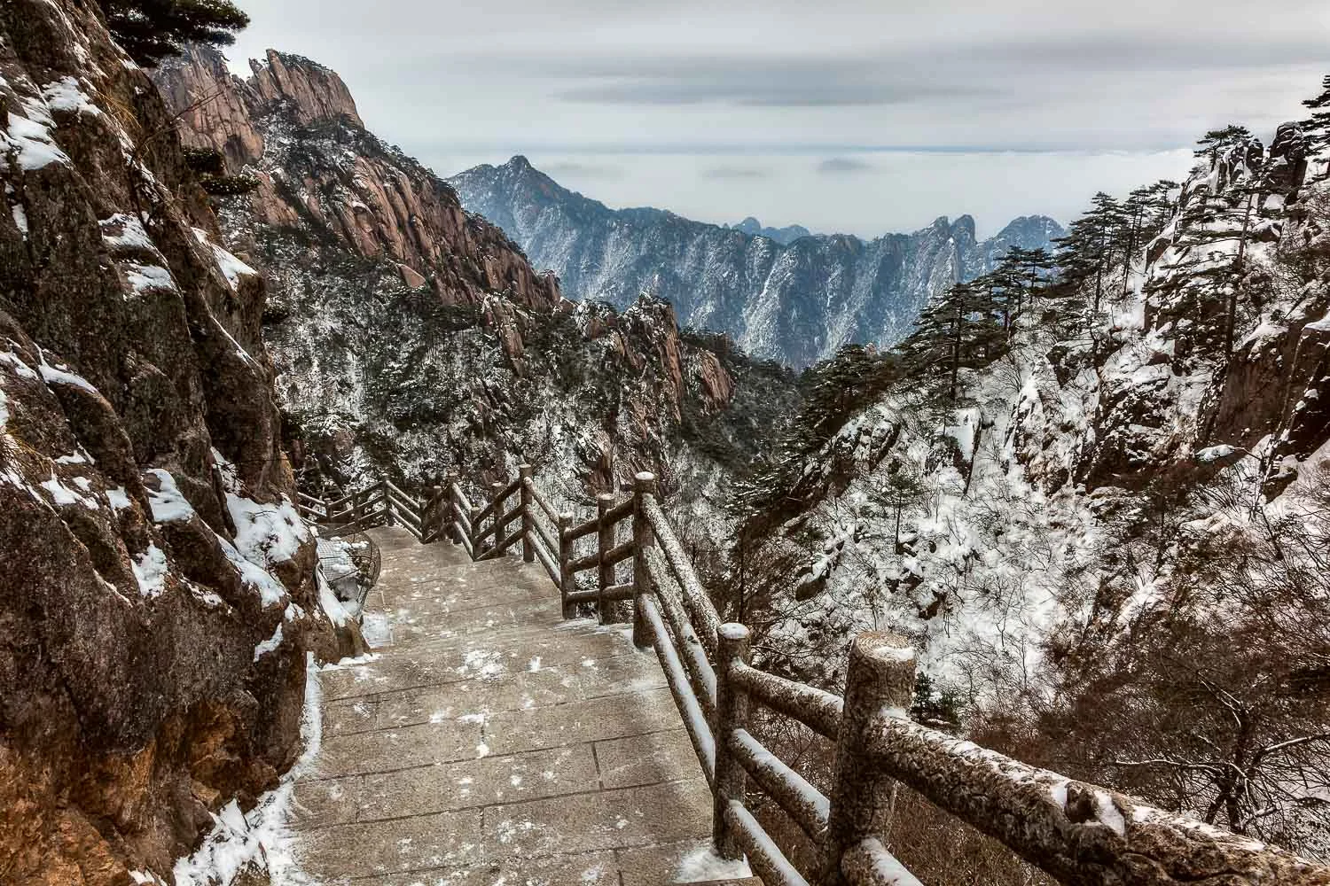A scattering of snow, on and around the mountain trail, on Huangshan (Yellow Mountain), China .