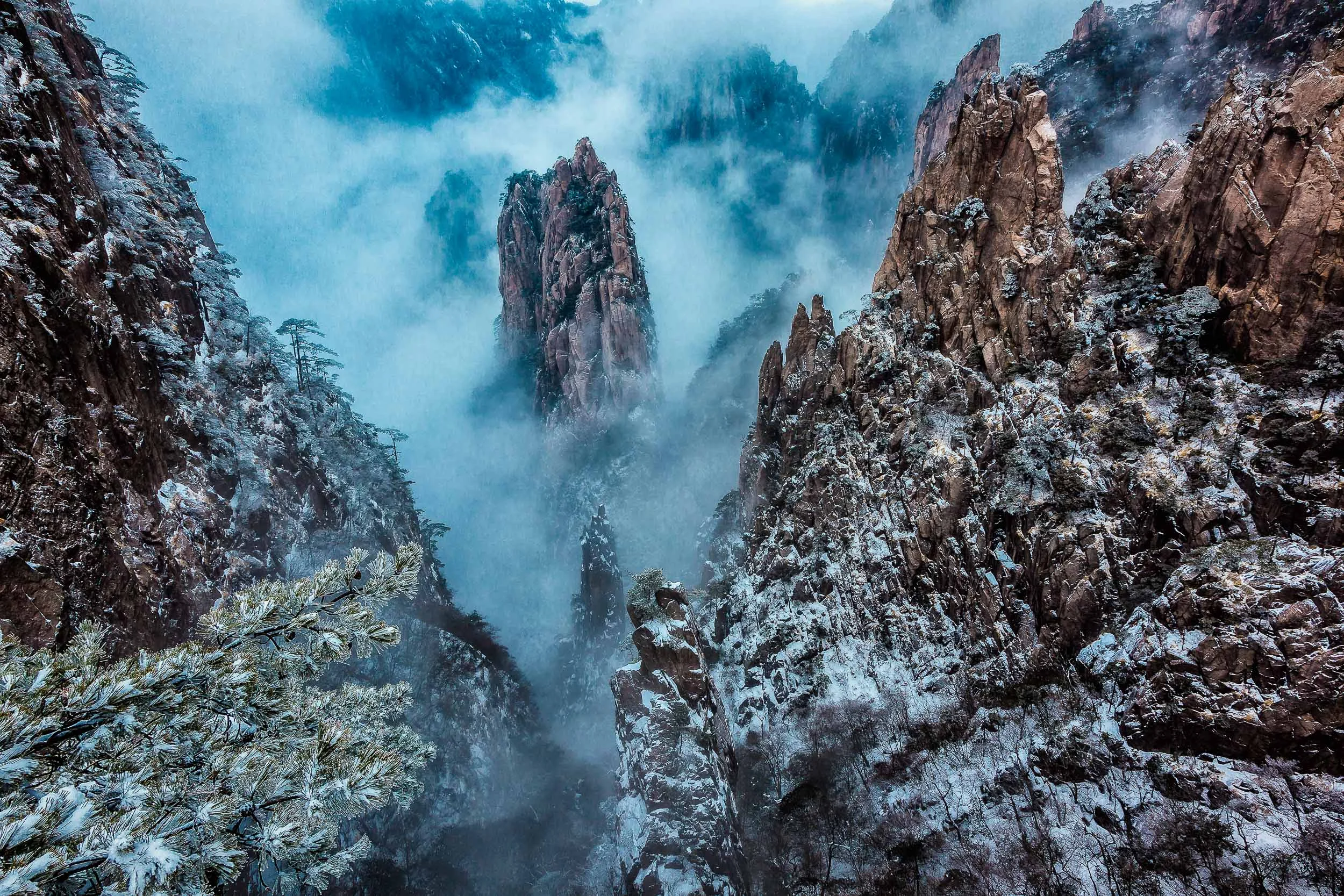 Mist swirling around peaks of stone on Huangshan (i.e., Yellow Mountain), China .