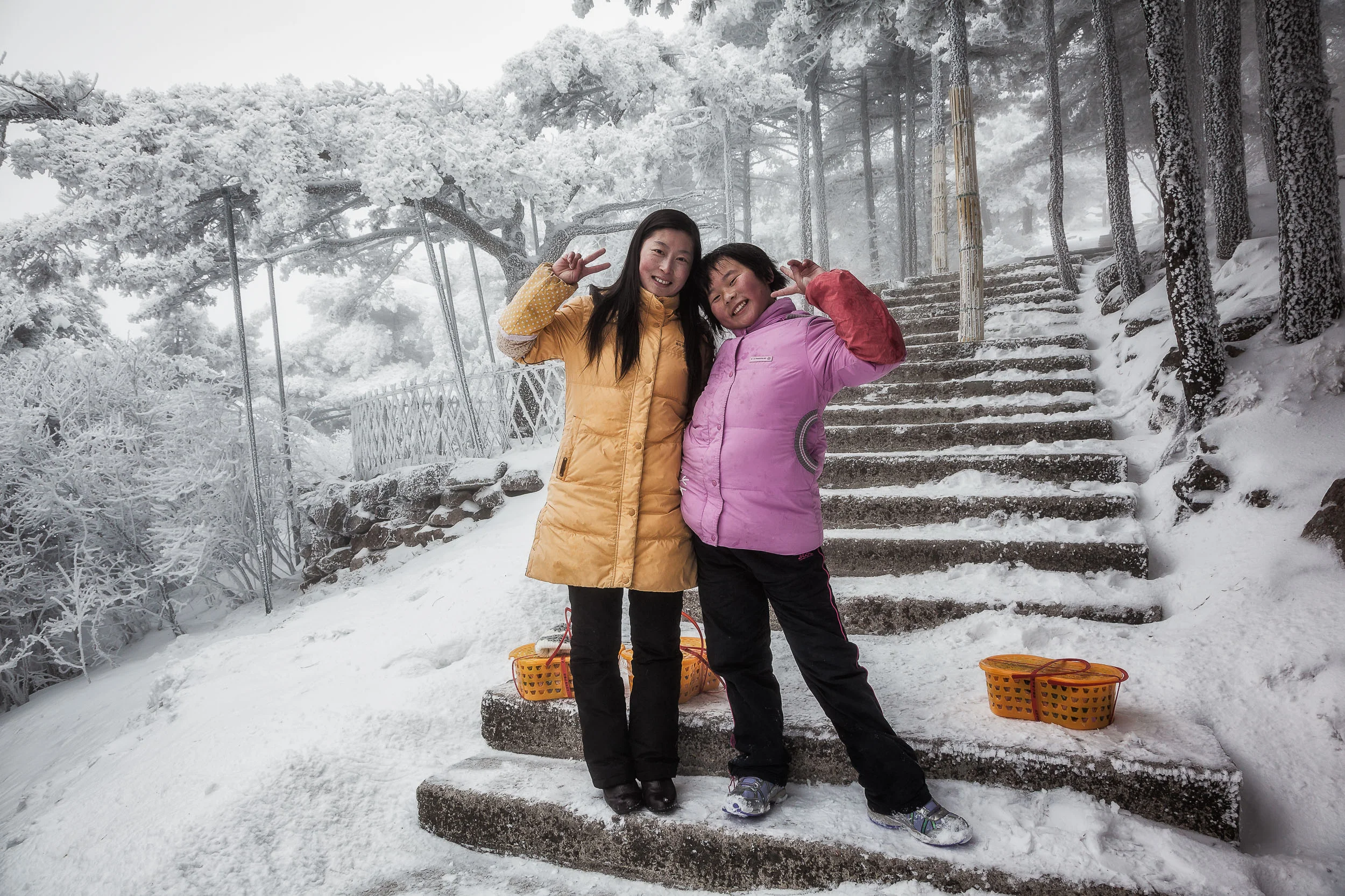 Two girls pose for a photo with the 'V for Victory' on the slopes of Huangshan in eastern China .