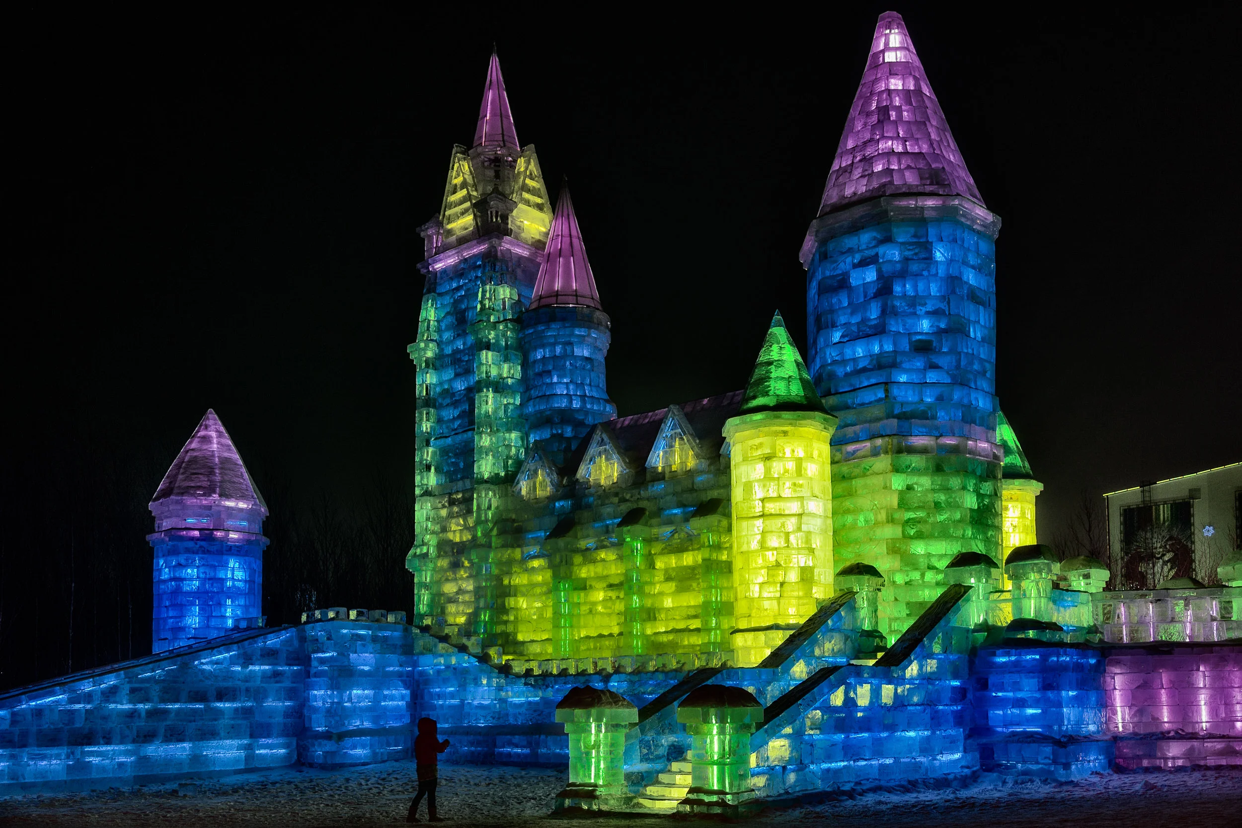 A magical and somewhat kitsch castle , made of ice and illuminated at night, at IceWorld in Harbin, China .