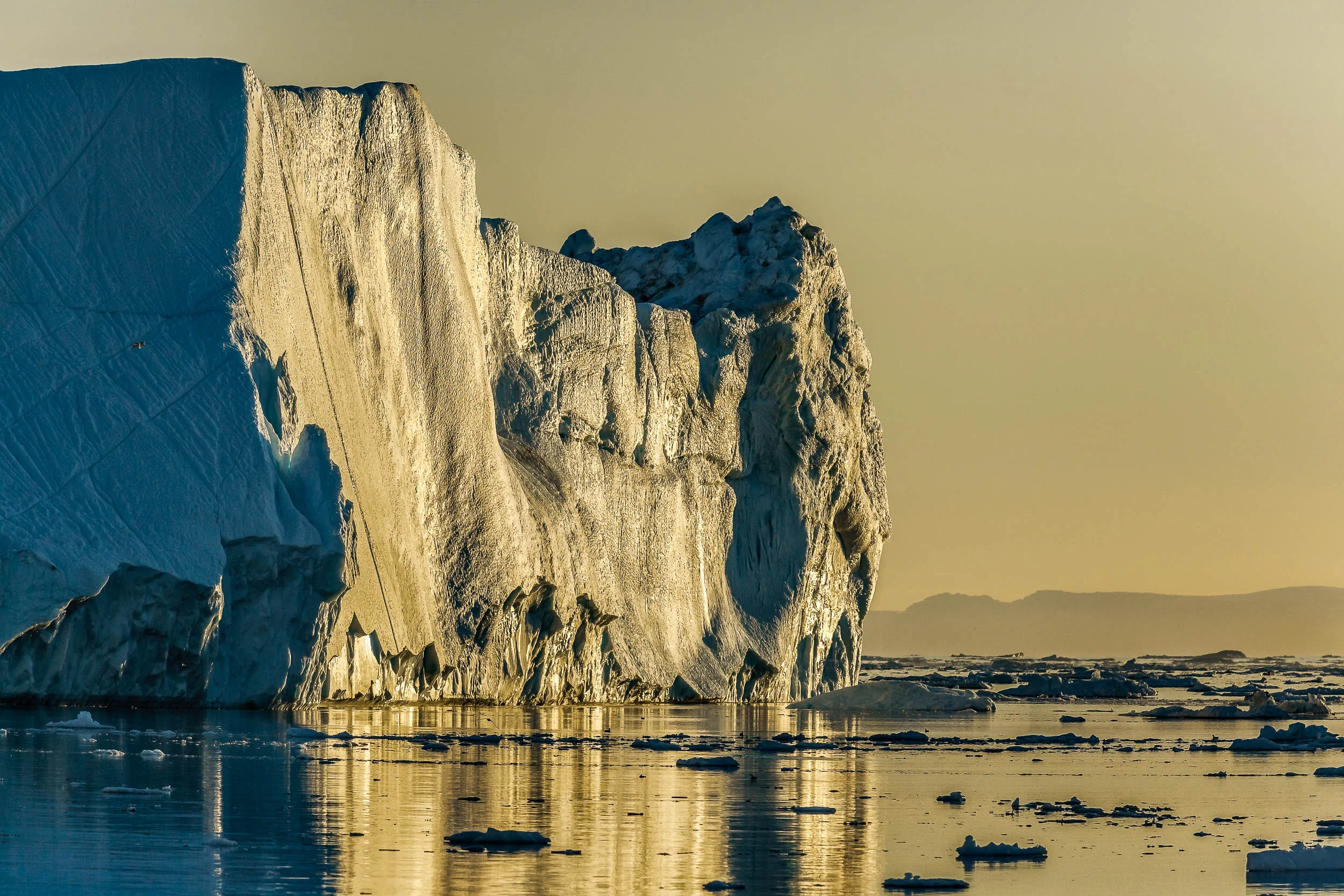 A giant iceberg photographed under the midnight sun on the Ilulissat Icefjord near the town of Iluliisat in Western Greenland .