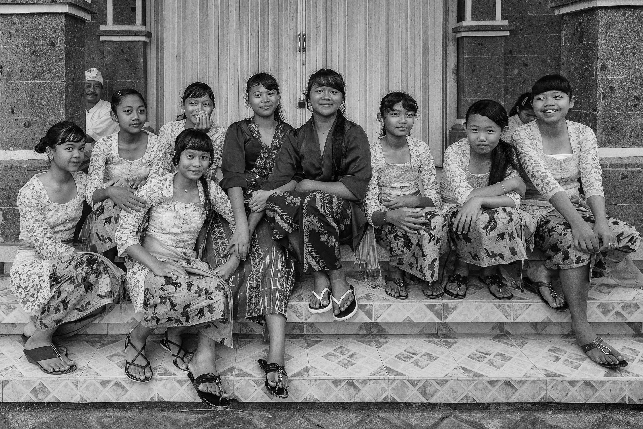 A casual portrait of a group of young women , in traditional dress, in rural Bali, Indonesia .