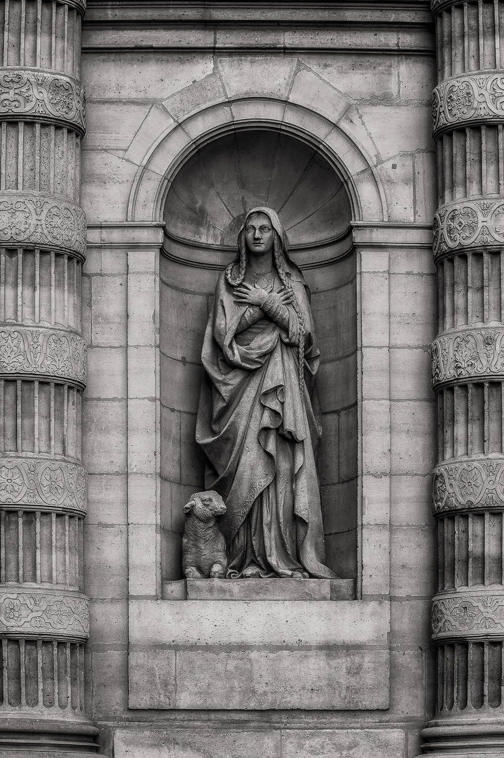 Paris is a beautiful city full of history and amazing architecture . Many of the ciiy's grand buildings include delights such as the statue found in this niche.