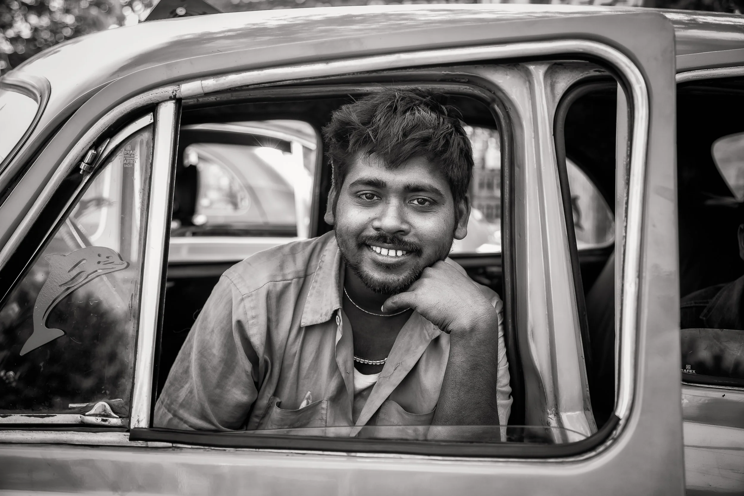 Smiling taxi driver at rest in a backstreet of Kolkata, India.