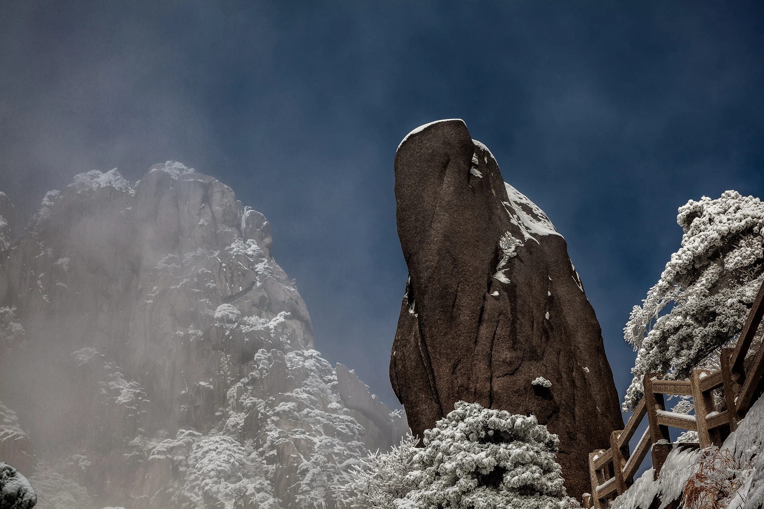 Receding mist reveals a view rich in shape and texture on Huangshan (i.e., Yellow Mountain) in China .