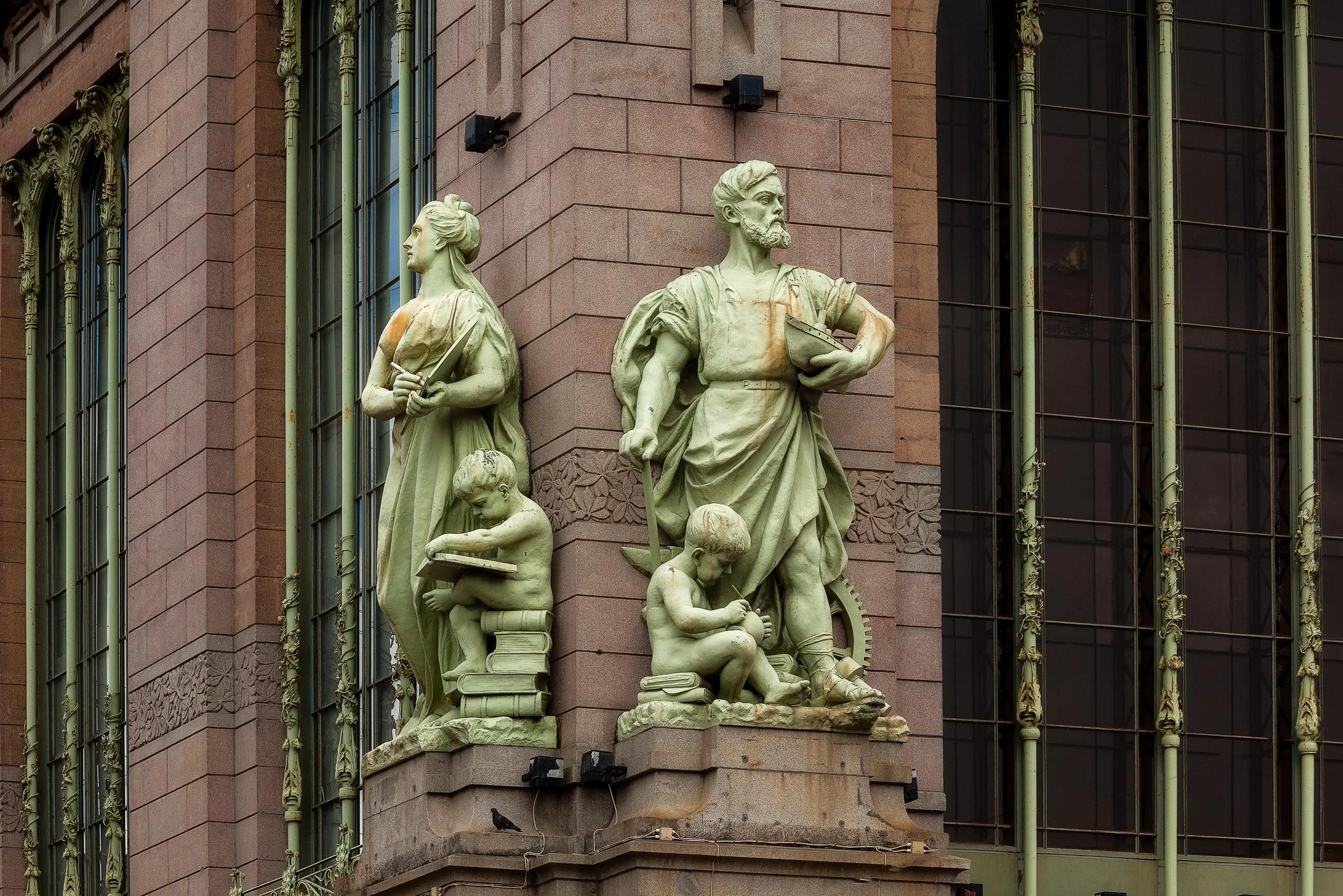 Statues signifying strength and learning on an historic building facade above the Neva River in St. Petersburg, Russia .