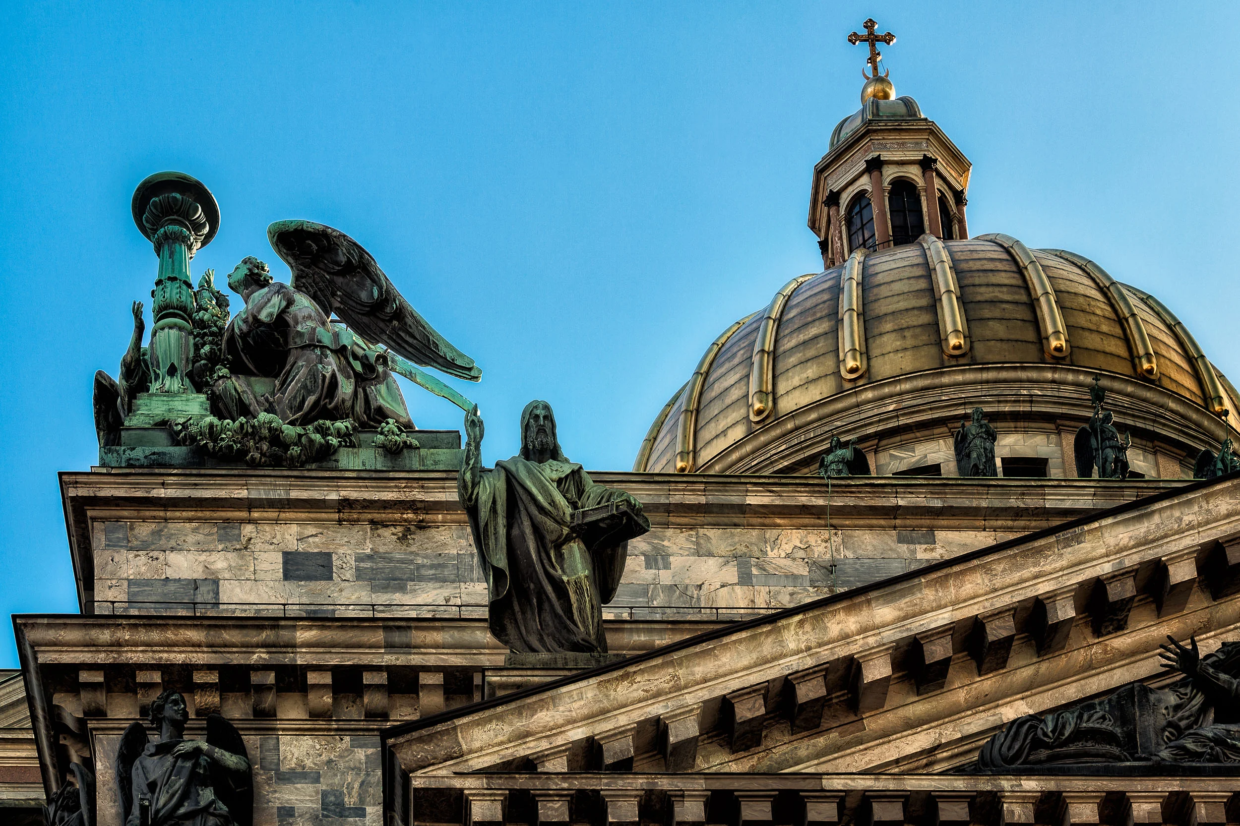 A dramatic view of the dome and statues at St. Isaac's Cathedral , St. Petersburg, Russia .