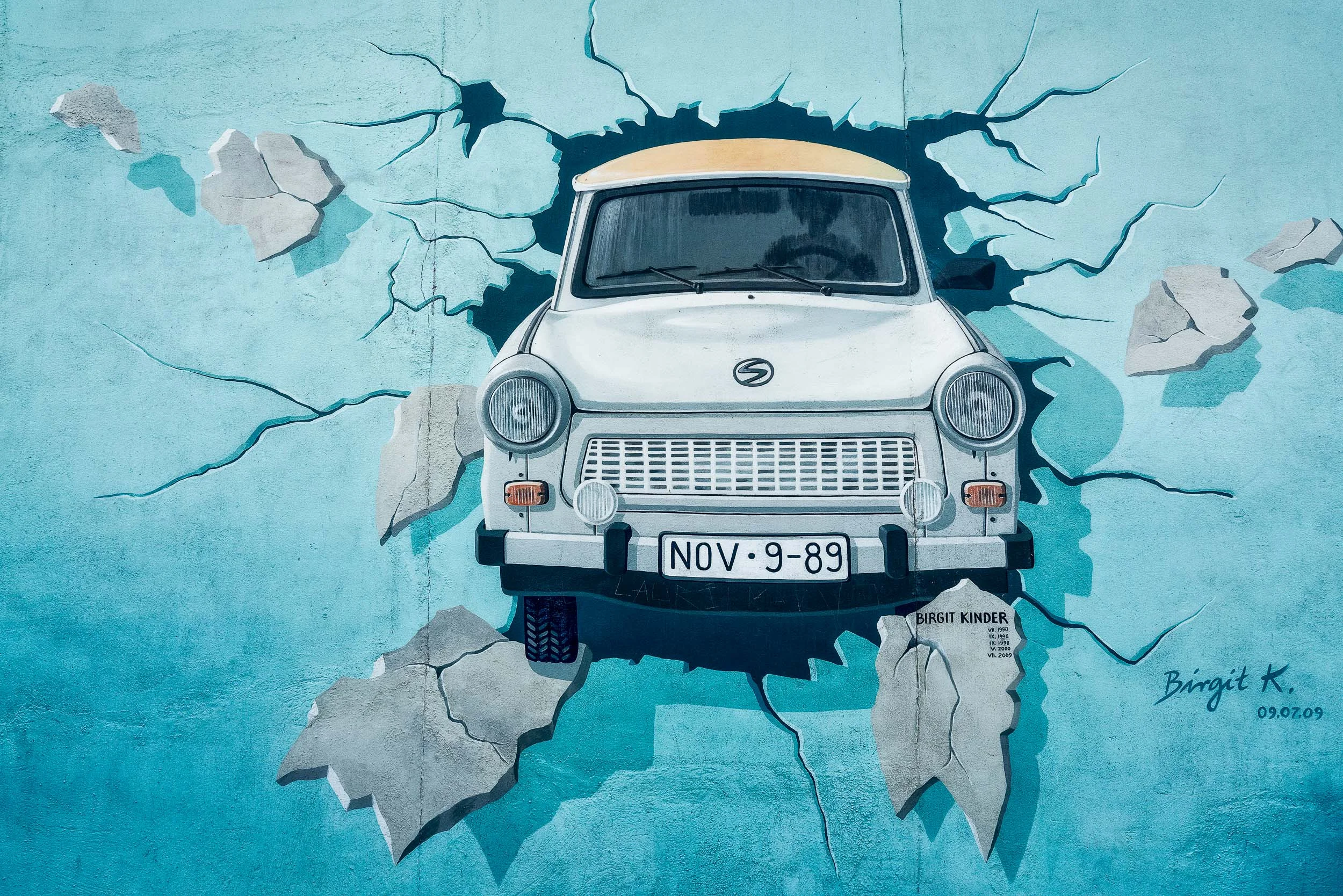 The artist Birgit Kinder's painting of a soviet manufactured Trabant car breaking through the Berlin Wall shows a license plate displaying the date the wall fell.