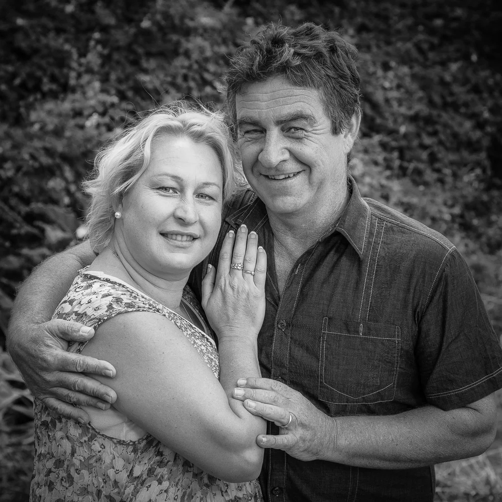 Couple embracing in a leafy outdoor setting in Hamilton, Australia .